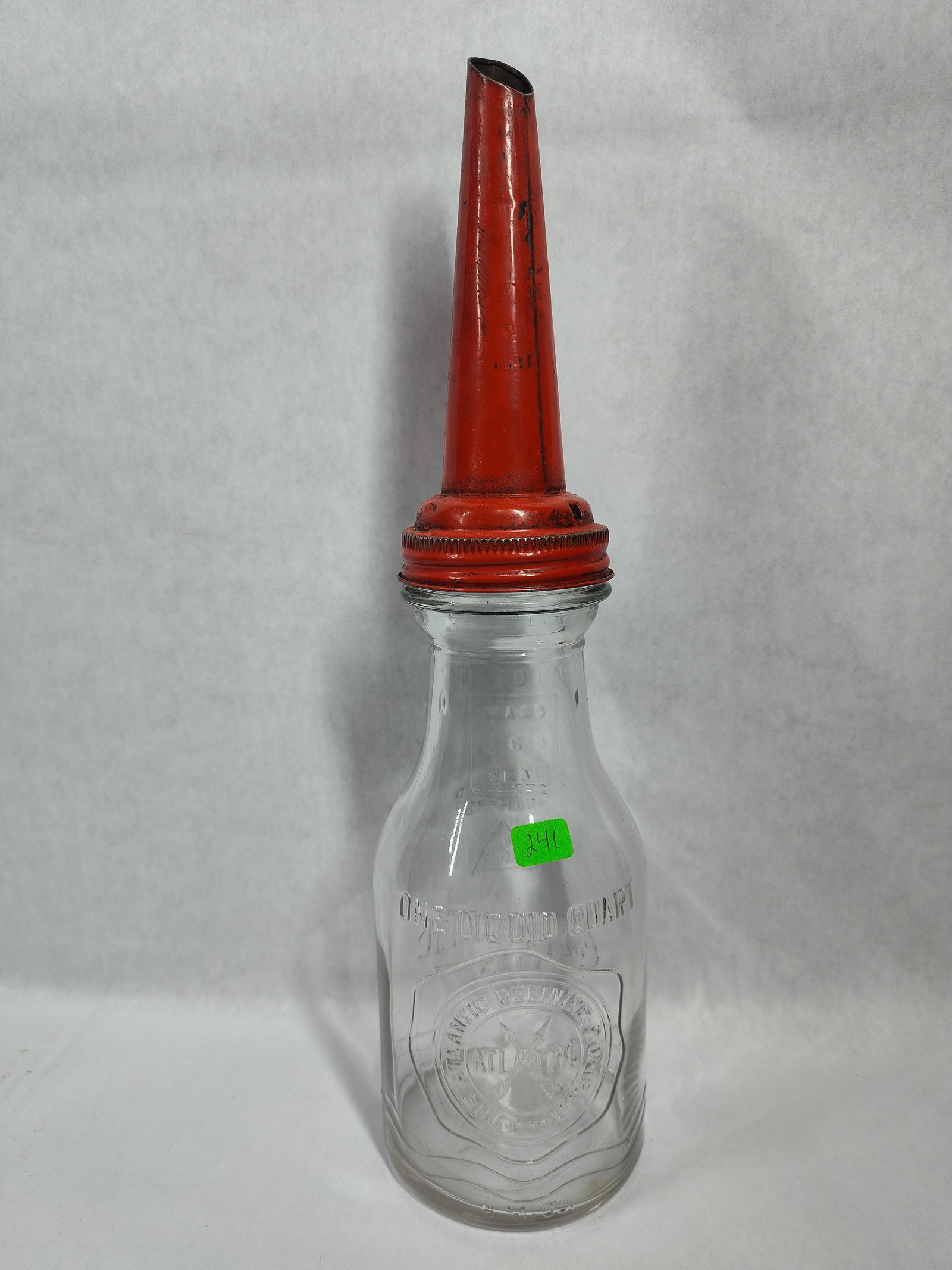 Atlantic Refining Co. Motor Oil Bottle w/ Spout: This is a vintage one-liquid-quart motor oil service bottle featuring a clear glass body and a red-painted metal screw-on pour spout. The bottle was produced for The Atlantic Refining Company and