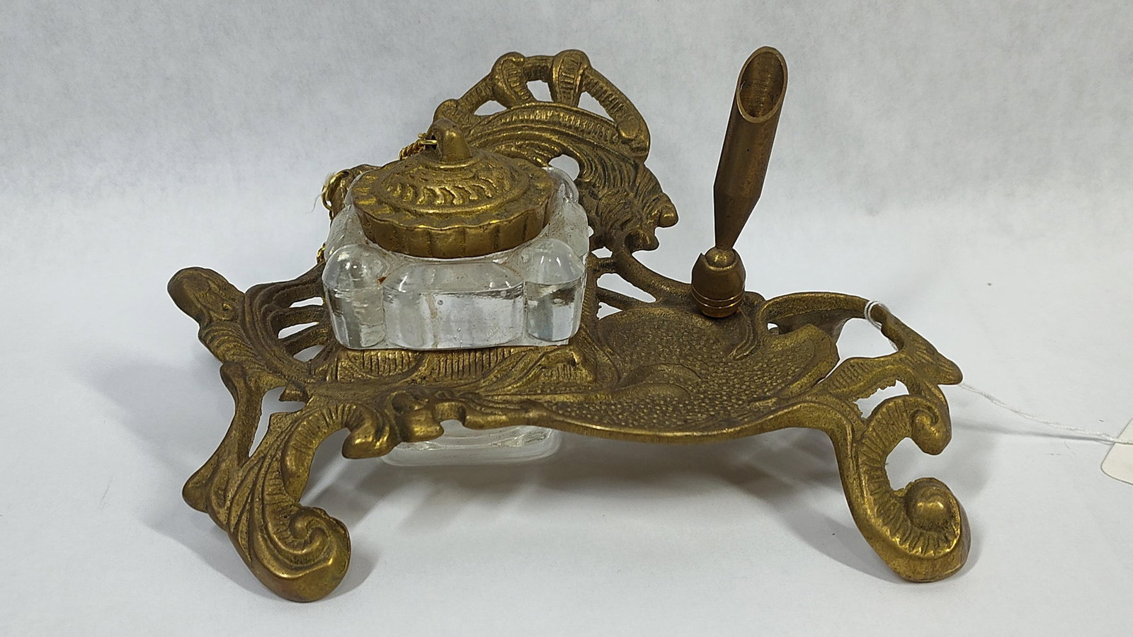 Art Nouveau Style Cast Brass & Glass Inkstand: This decorative desk set features a cast brass frame designed in the Art Nouveau style, characterized by asymmetrical organic forms and stylized foliate scrolls. The frame rests on four scrolling