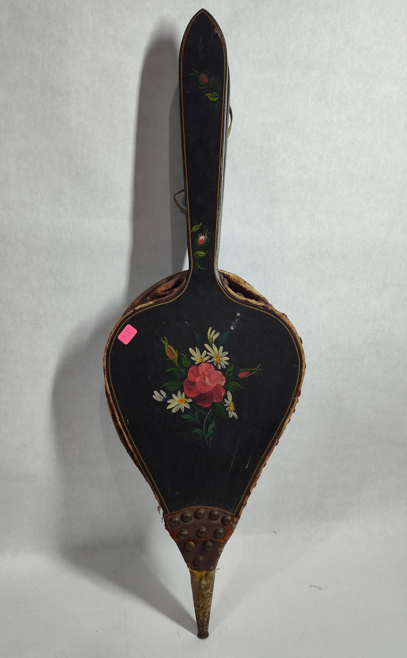 Antique Hand-Painted Wood & Leather Bellows: An antique fireplace hand bellows constructed of two black-painted wood panels joined by a brown leather gusset. The leather is secured to the wooden frames with a series of decorative brass-toned