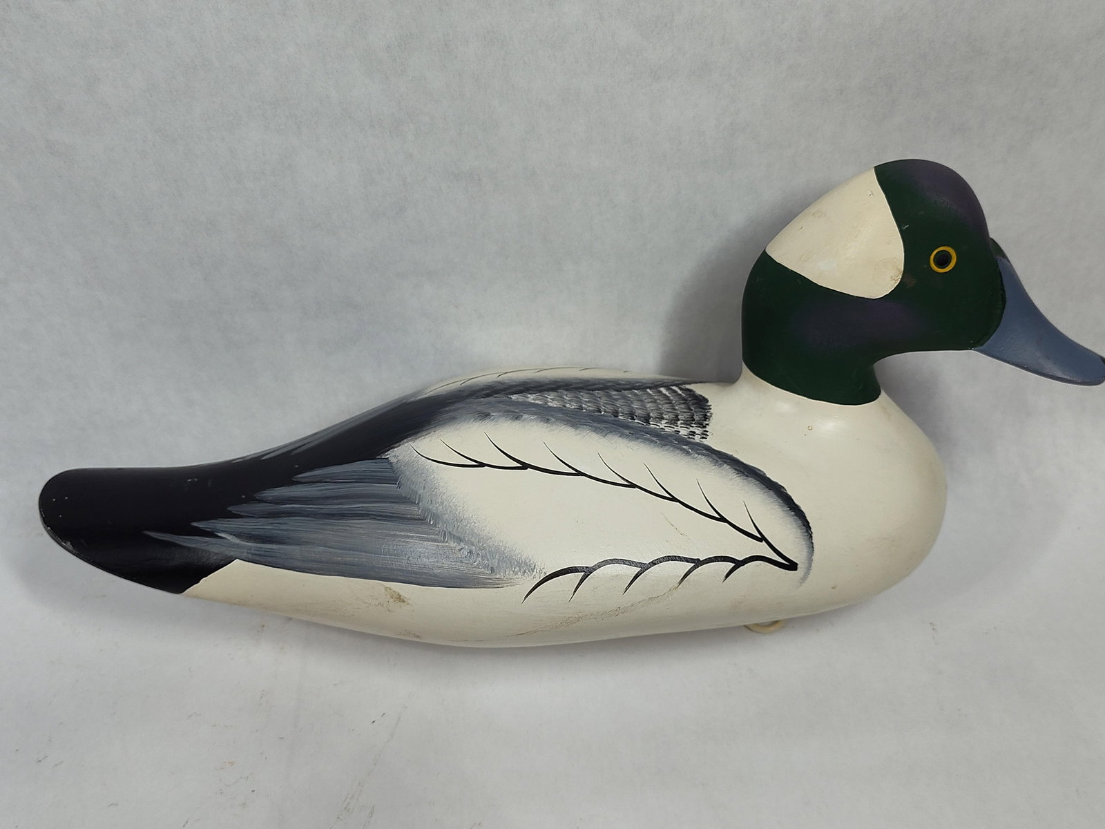 Charles Jobes Bufflehead Drake Wooden Decoy 2005: This hand-carved and painted wooden duck decoy by Charles Jobes depicts a male Bufflehead drake. The figure features a white body with gray and black painted feather details along the wings and tail.