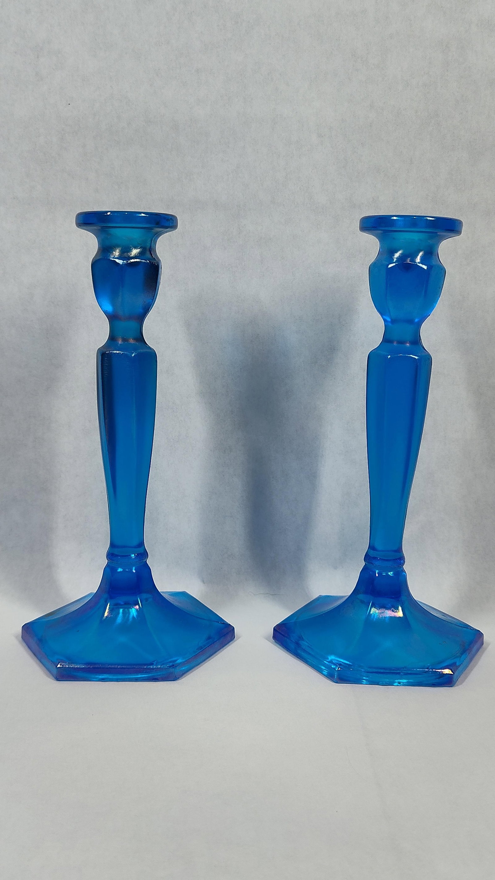 Pair attr. Fenton Celeste Blue Stretch: A pair of vintage iridescent stretch glass candlesticks in the Colonial pattern, attributed to Fenton Art Glass. The pieces are finished in a Celeste Blue color with an iridized surface treatment.
