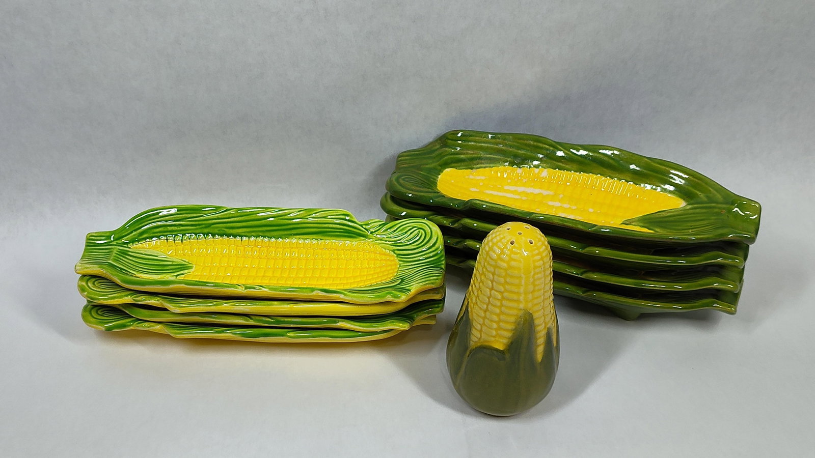 Vtg Ceramic Corn-Themed Tableware: This collection consists of ceramic tableware items molded in the form of husked ears of corn. The group includes several elongated serving boats designed for corn-on-the-cob and a single upright