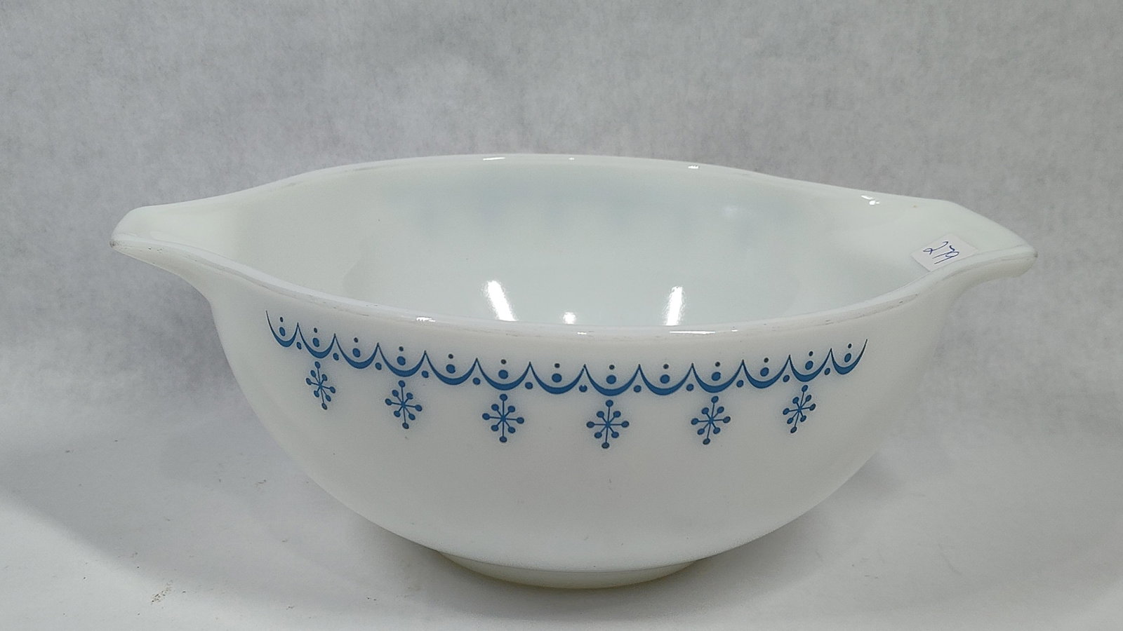 Pyrex Snowflake Blue 441 Cinderella Mixing Bowl: A vintage Pyrex Cinderella-style mixing bowl, model number 441, which was the smallest size in the standard nesting set. The bowl is crafted from white opal glass and features the Snowflake Blue