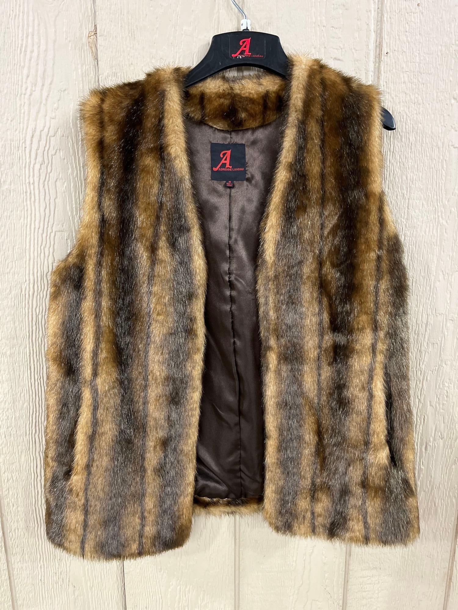 Adrienne Landau Faux Fur Vertical Striped Vest: This sleeveless open-front vest by designer Adrienne Landau is crafted from plush faux fur featuring a variegated vertical striped pattern in shades of brown and tan, intended to mimic the appearance 