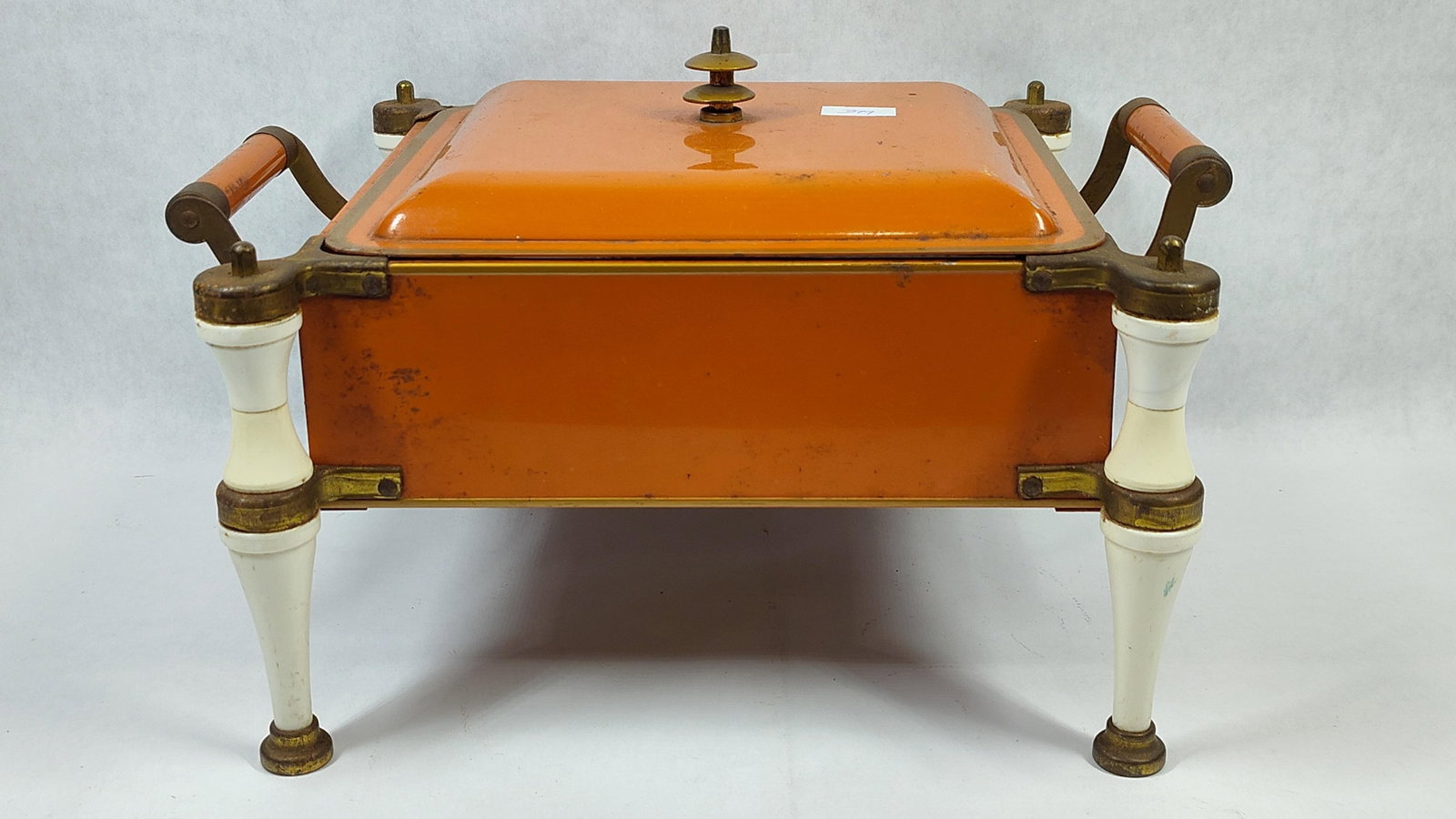 Art Deco Style Orange Enamel & Brass Chafing Dish: An Art Deco style electric food warmer or chafing dish, often attributed to the King Chafing Dish company. The unit features a rectangular metal body and a matching lid, both finished in a vibrant