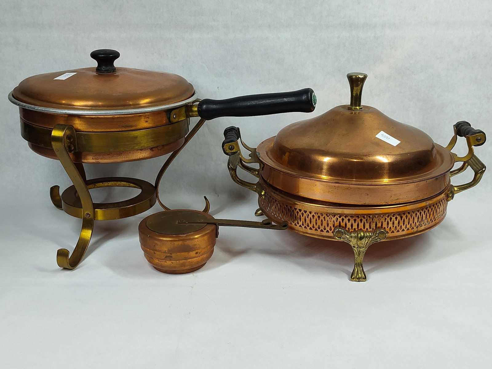 Pair Mid-C. Copper & Brass Chafing Dishes w/: A pair of mid-century vintage copper and brass chafing dishes, suitable for buffet-style serving. The first assembly includes a copper pan and domed lid with a black circular knob and a long, turned
