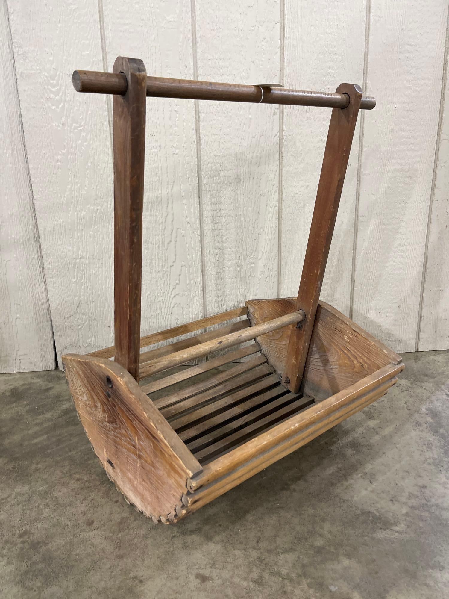 Primitive Wood Slatted Garden Trug: This primitive wooden garden trug or vegetable harvesting basket features a bed constructed from multiple horizontal wooden slats attached to solid, rounded end panels. This design allows for the drai