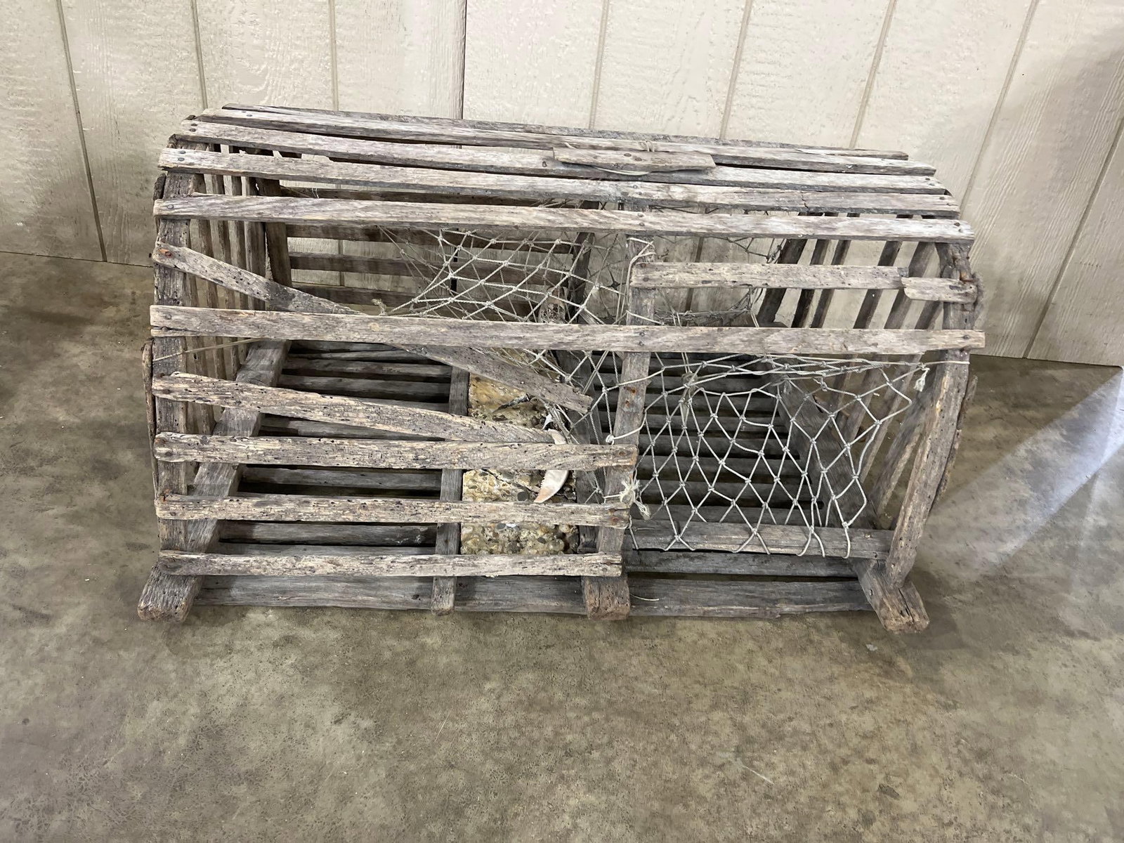 Vtg Wood Lobster Trap w/ Internal Netting: This traditional lobster trap is constructed in a bowed or half-round design using weathered wooden slats and a heavy timber base. The interior features remnants of hand-tied rope netting funnels,