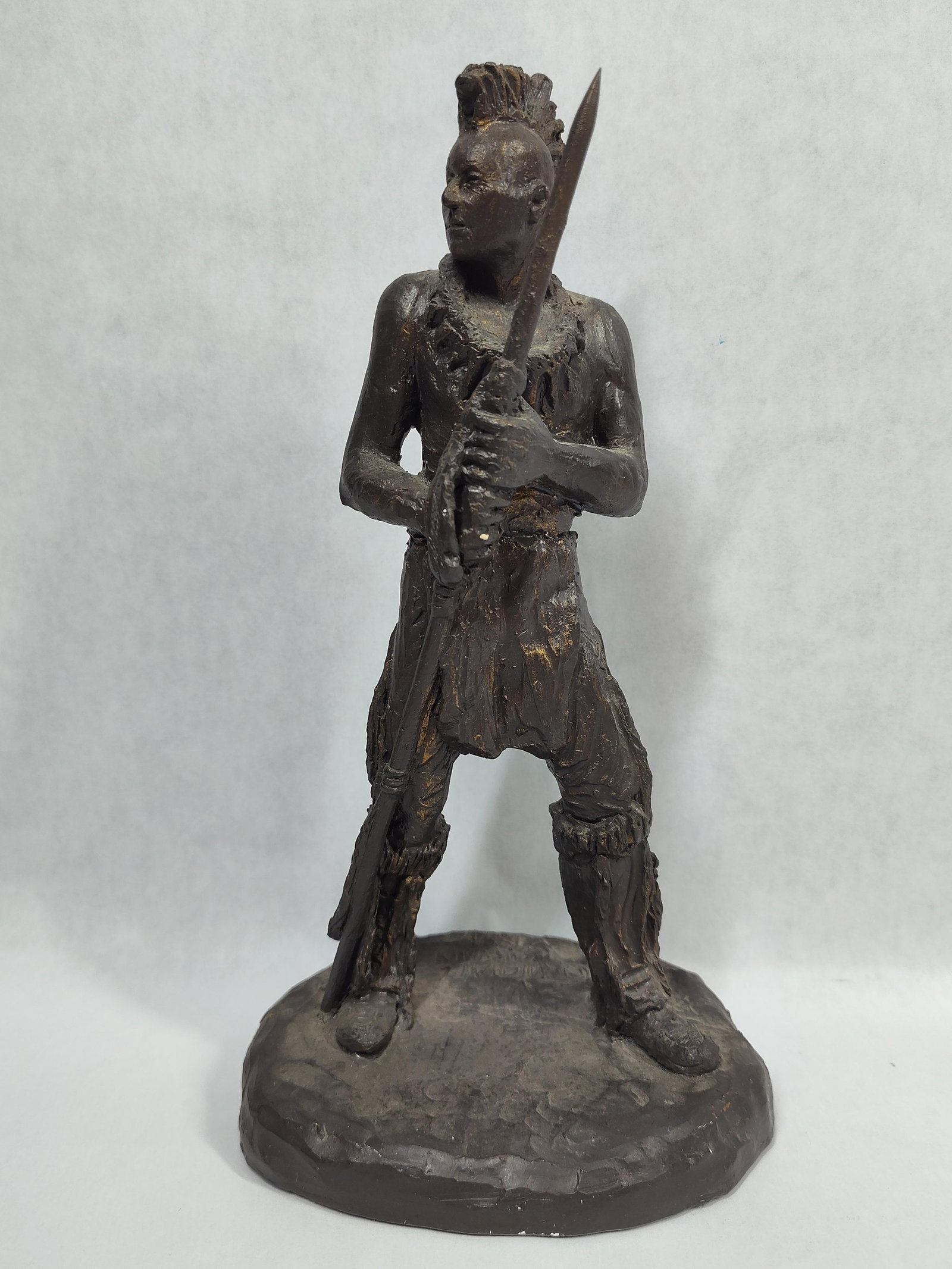 Michael Garman Resin Native American Warrior, 1991: This cast resin sculpture with a dark bronze-toned finish is a work by Michael Garman (American, 1938-2021). The figure depicts a standing Native American warrior, rendered in the style of the
