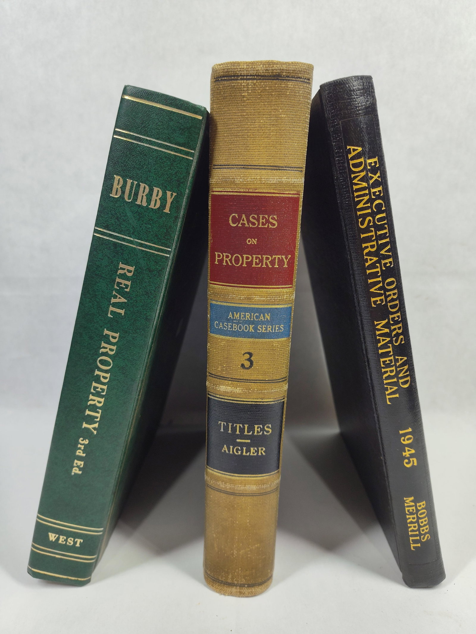 West Publishing Co. 3 Law Volumes, Aigler, 1916: A collection of three legal volumes focused on property law and administrative orders. The oldest volume is Cases on the Law of Property, Volume 3: Titles to Real Property, authored by Ralph W.