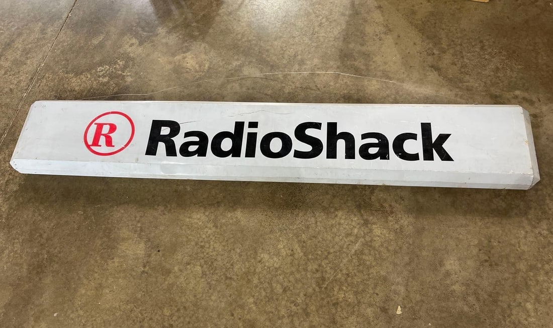 RadioShack Illuminated Storefront Sign: An original retail sign for the American electronics retailer RadioShack. This item is a large, rectangular commercial lightbox or storefront sign. The face is constructed from a translucent white