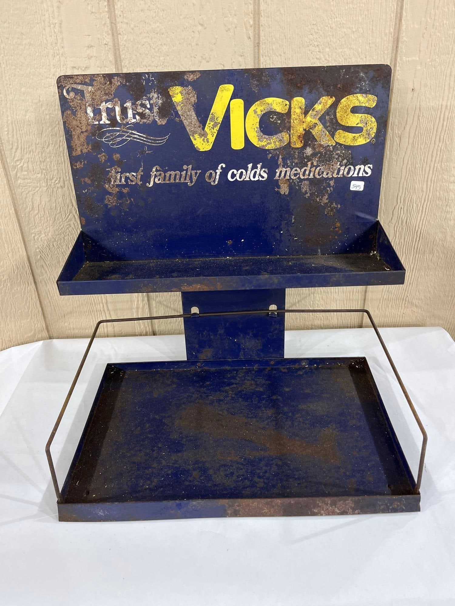 Vicks Blue Metal 2-Tier Drugstore Advertising Rack: A mid-century point-of-sale retail display rack for Vicks cold remedies, constructed of blue-painted sheet metal with wire components. The unit is designed with two tiers, including a shallow upper