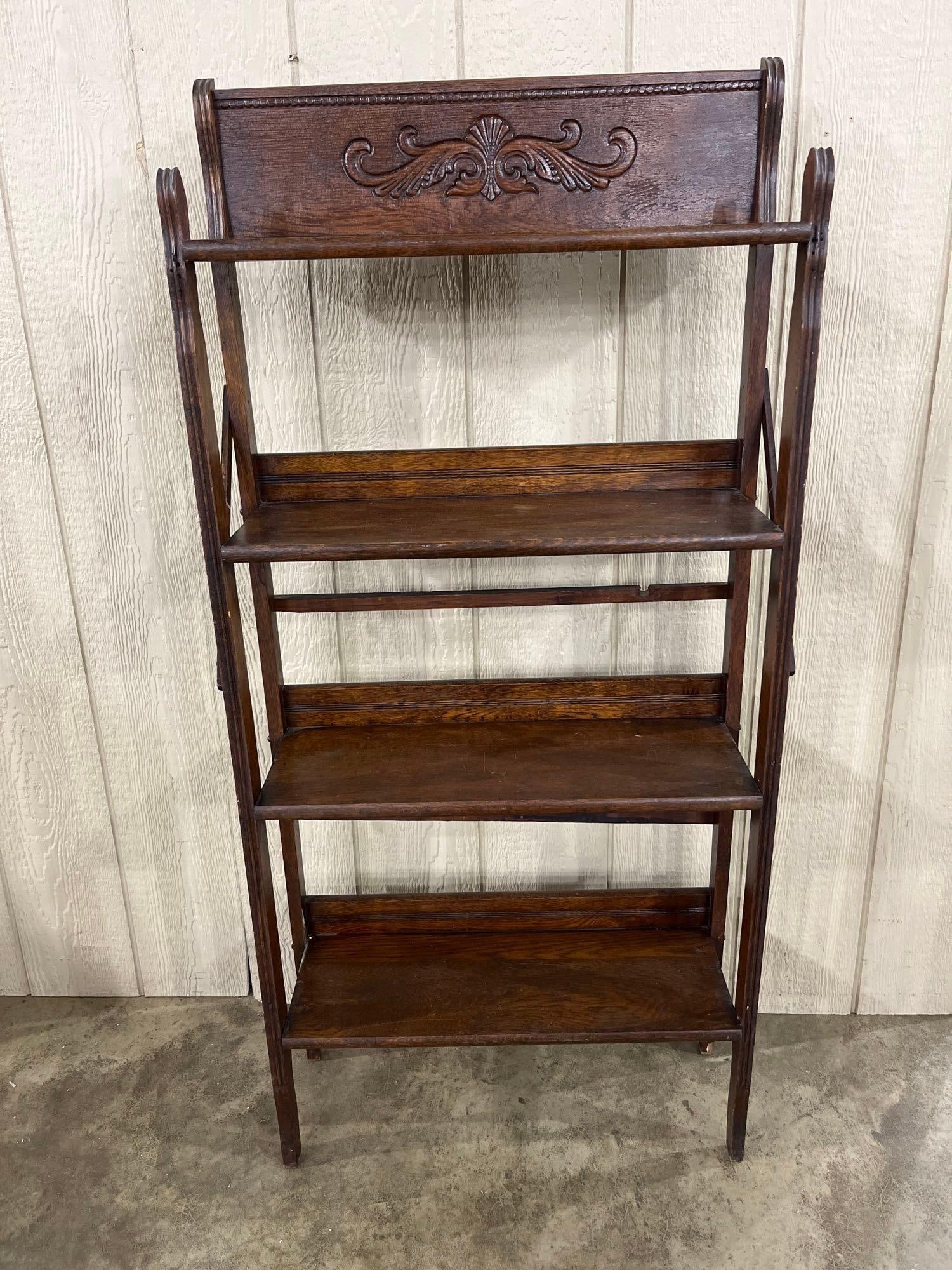 Quartersawn Oak Folding 4-Tier Etagere w/ Crest: An early 20th-century folding display shelf constructed from oak. The unit features a four-tier design and is topped by a decorative crest rail featuring a carved central shell and foliate scroll