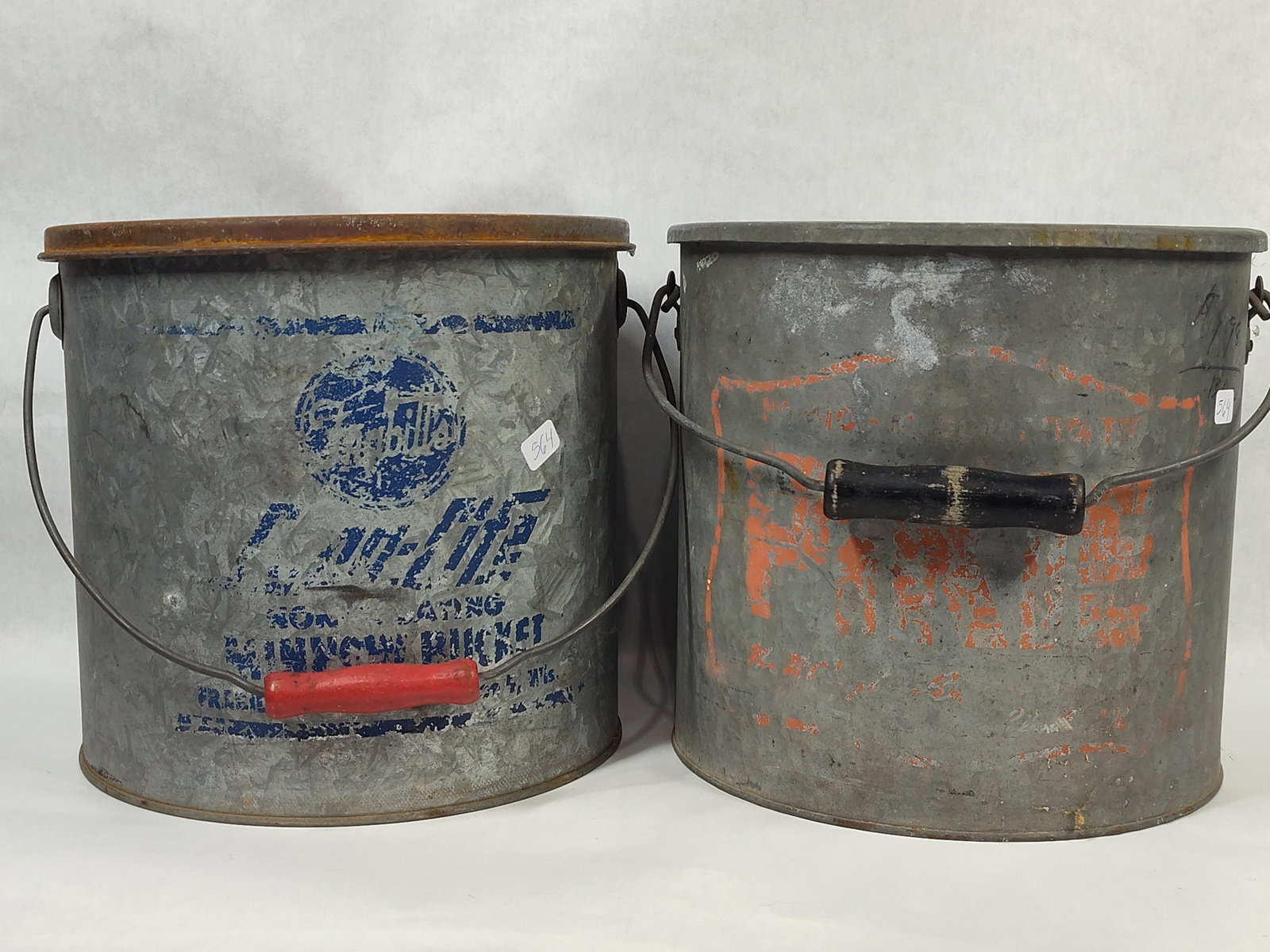 Pair Falls City & Pride of the Lake Minnow Buckets: This lot features two vintage two-piece galvanized metal minnow buckets dating to the mid-20th century. The first bucket is a Falls City Air-Life floating model constructed of galvanized steel. It inc