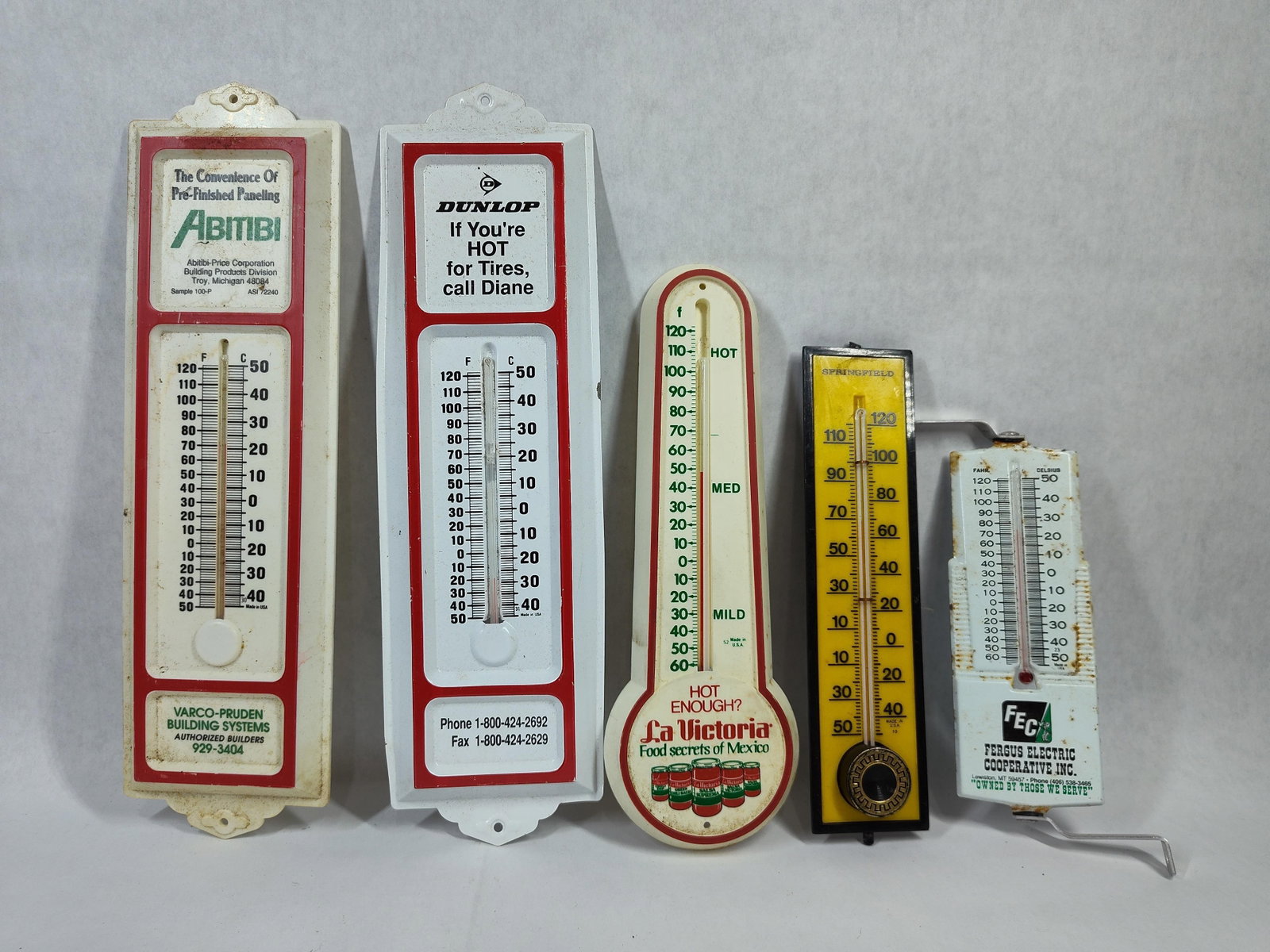 Vtg Advertising & Utility Thermometers: A collection of several vintage advertising and utility wall thermometers from the mid-to-late 20th century. The lot includes two vertical thermometers with white and red plastic housings: one