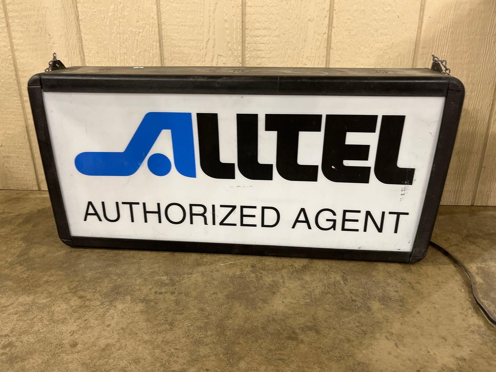 Alltel Authorized Agent Illuminated Lightbox Sign: This is an illuminated advertising lightbox sign for Alltel, a former American telecommunications company. The sign consists of a translucent white acrylic face mounted within a molded black frame. Th