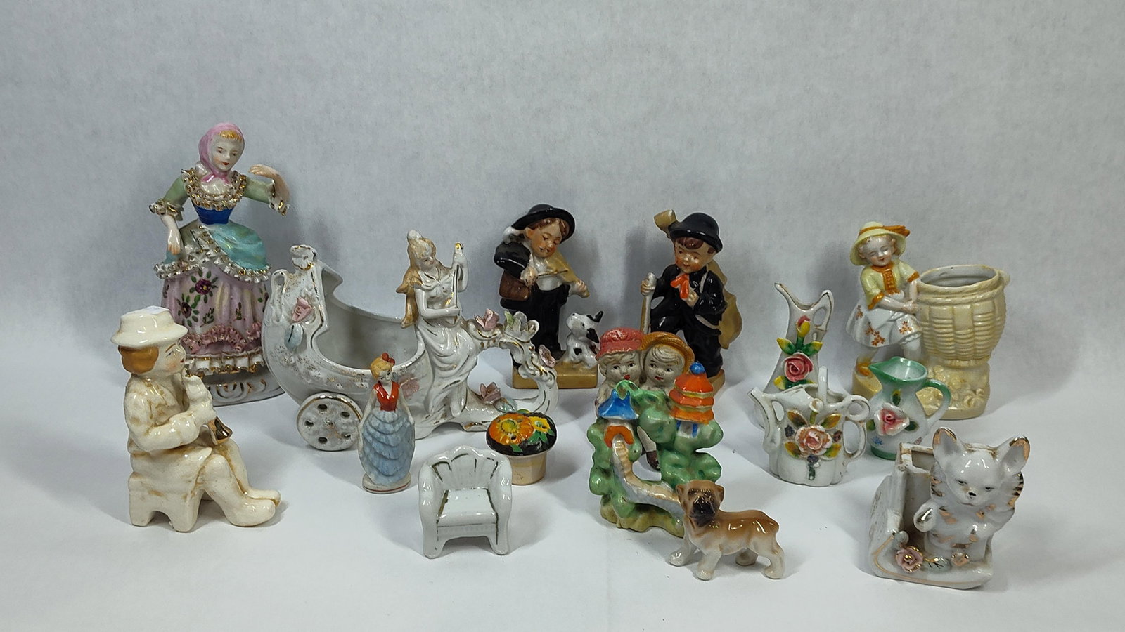 Vtg Porc. & Ceramic Figurines & Miniatures: An assortment of decorative figurines and miniatures crafted from glazed porcelain and bisque ceramic. The collection features several character studies including a tall woman in eighteenth-century