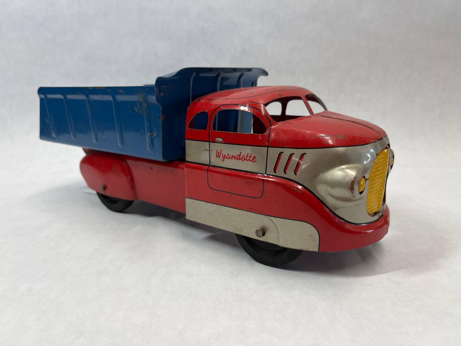 Wyandotte Pressed Steel Streamlined Dump Truck: This pressed steel toy dump truck was manufactured by Wyandotte Toys (All Metal Products Company) in the United States, dating to approximately the late 1930s or 1940s. The toy features an Art