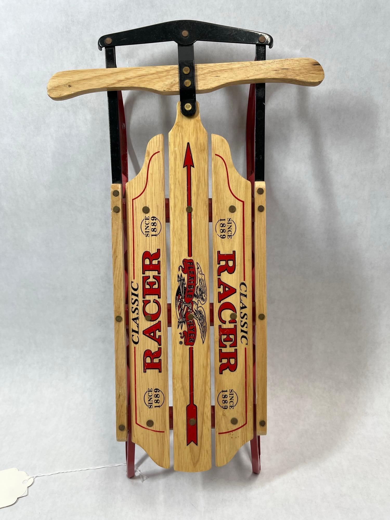 Flexible Flyer Classic Racer Miniature Sled: This is a miniature wooden and metal sled produced under the Flexible Flyer brand name as part of the Classic Racer series. The item is a modern decorative reproduction of the iconic full-size pull