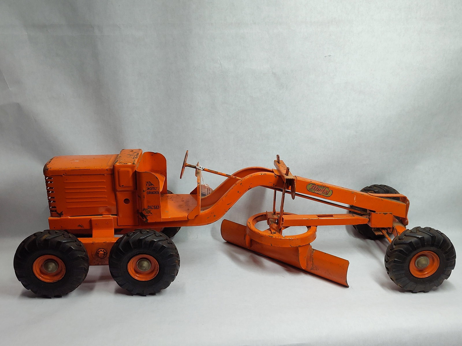 Doepke Model Toys Adams Diesel Motor Grader: This construction toy is an Adams Diesel Motor Grader manufactured by the Charles Wm. Doepke Manufacturing Company under the Model Toys brand. The piece is constructed from heavy-gauge pressed steel
