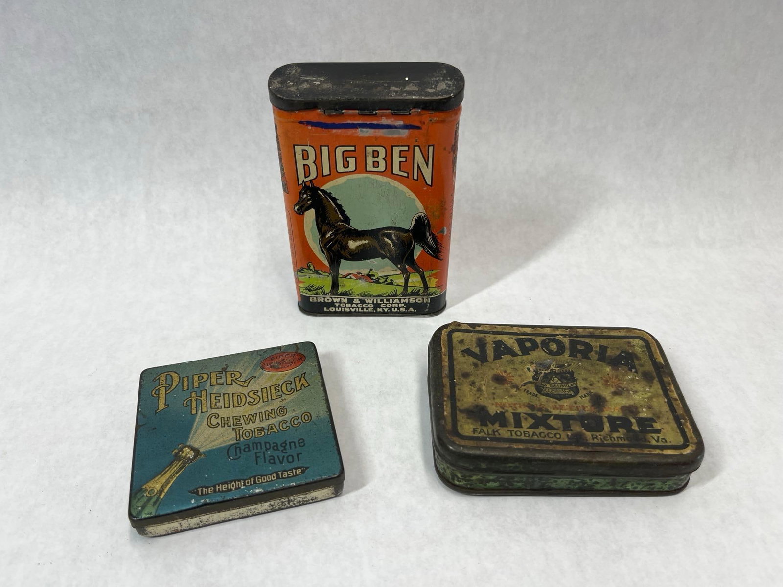 3 American Lithographed Tobacco Pocket Tins: This lot features three early to mid-20th century American advertising tobacco tins. The first is an upright pocket tin for Big Ben Smoking Tobacco, manufactured by the Brown & Williamson Tobacco