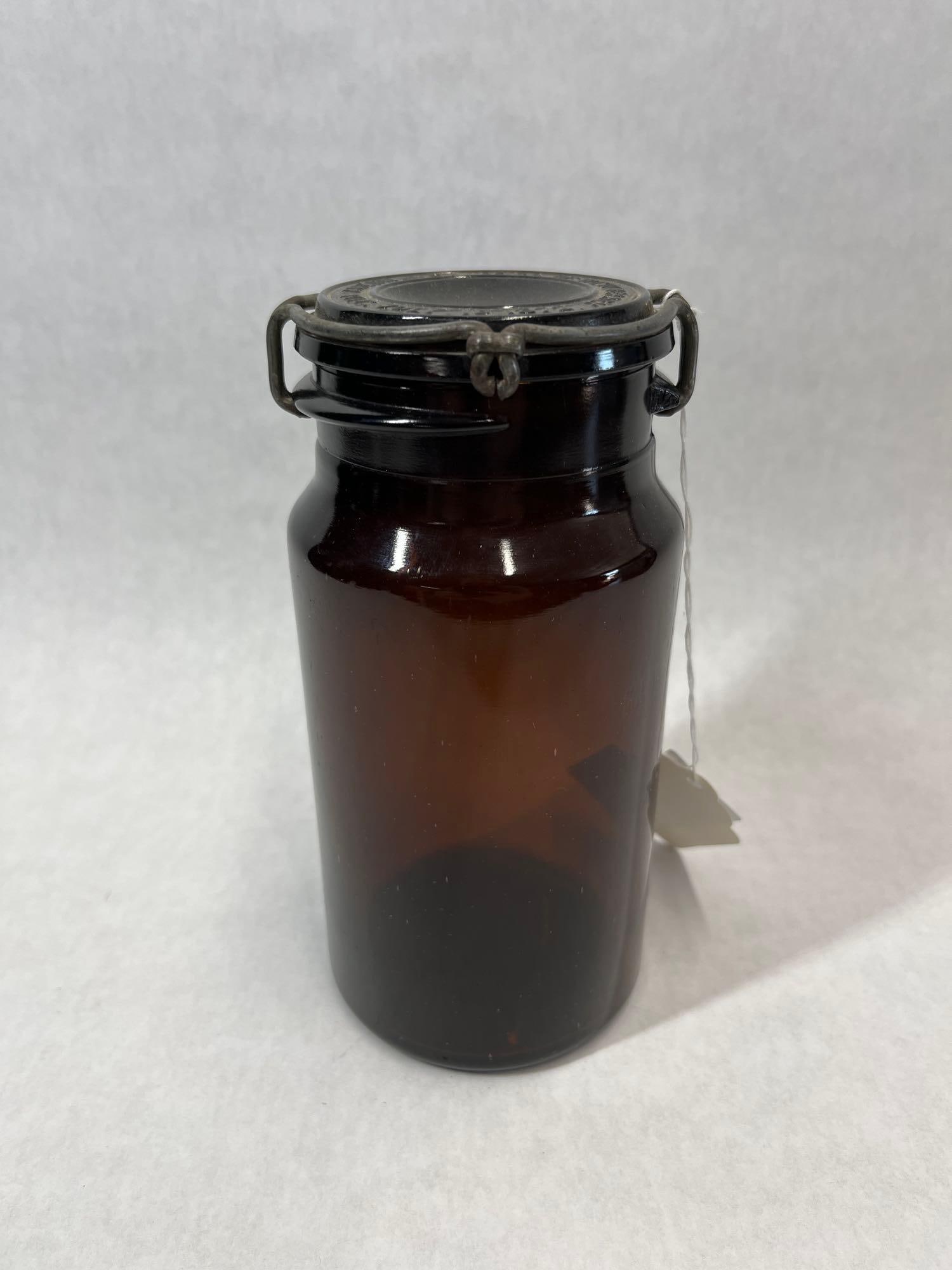 P. Lorillard American Snuff Amber Tobacco Jar: This antique cylindrical container is manufactured from mold-blown dark amber glass, designed for the storage of snuff or tobacco. The vessel features a wide mouth with a ground rim and is fitted with