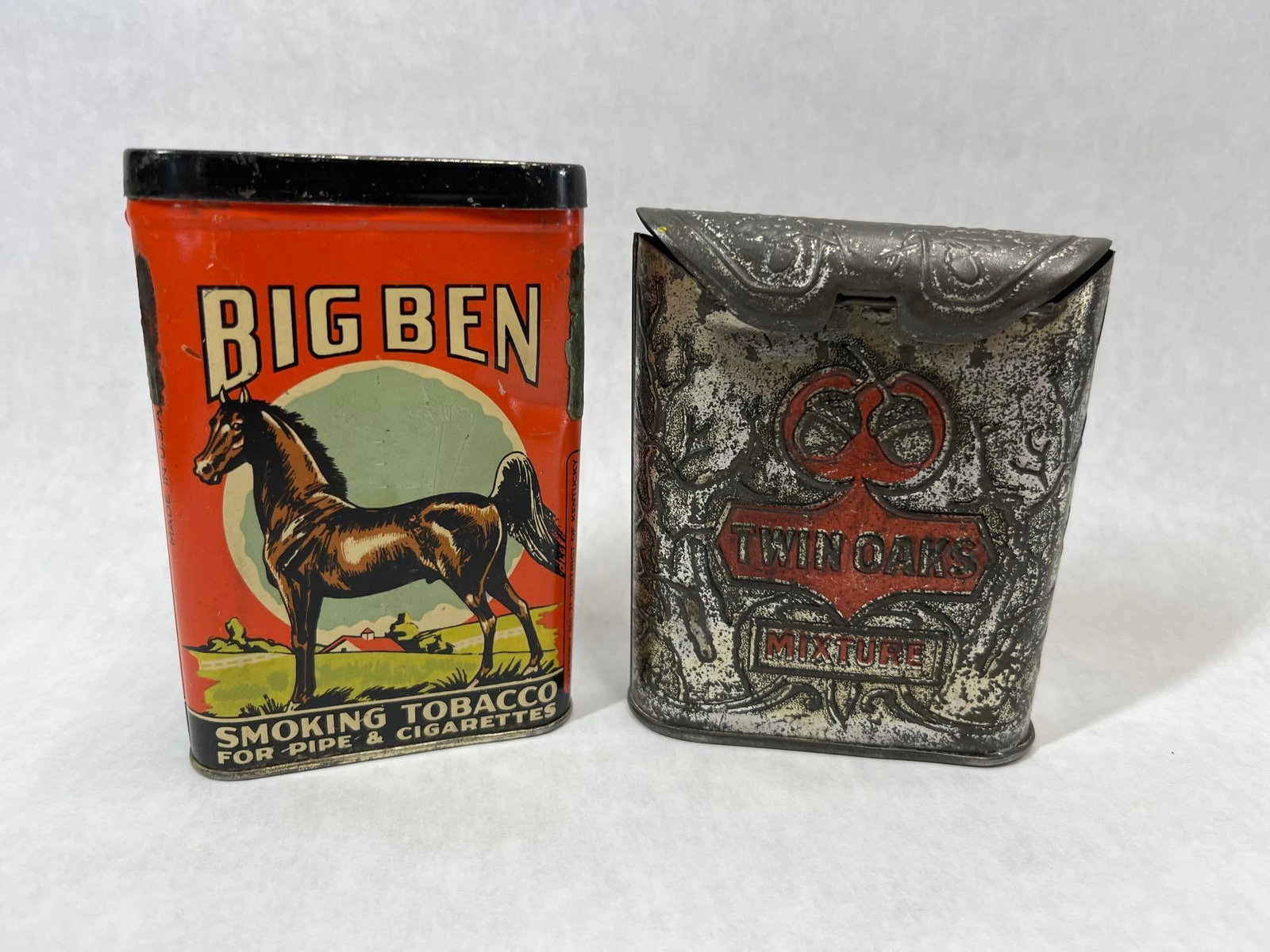 Two American Vertical Pocket Tobacco Tins, Big Ben and Twin Oaks: This lot features two American vertical pocket tobacco tins. The first is a Big Ben Smoking Tobacco tin, manufactured by the Brown & Williamson Tobacco Corporation. It is composed of lithographed