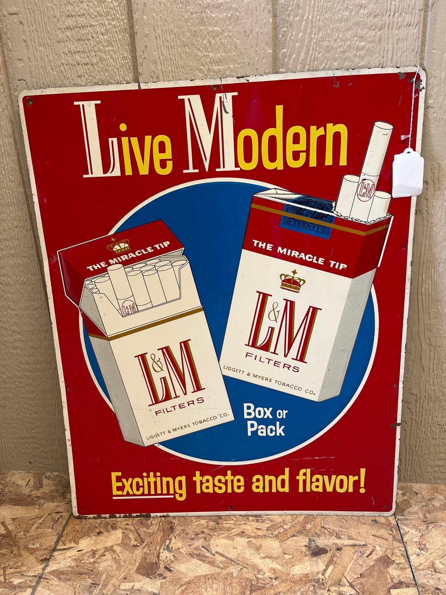 L&M Cigarettes Live Modern Embossed Metal Sign: This is a vertical rectangular advertising sign for L&M Filters cigarettes, produced for the Liggett & Myers Tobacco Co. The sign is constructed from painted embossed steel. The front features a