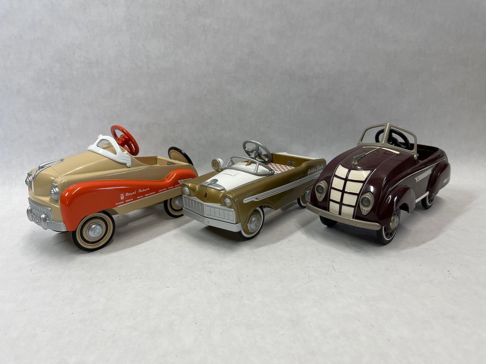 Three Hallmark Kiddie Car Classics Pedal Cars: A trio of scale replica miniature pedal cars from the Hallmark Kiddie Car Classics series. These collectibles are modeled after historical full-sized children's toys and are constructed with die-cast