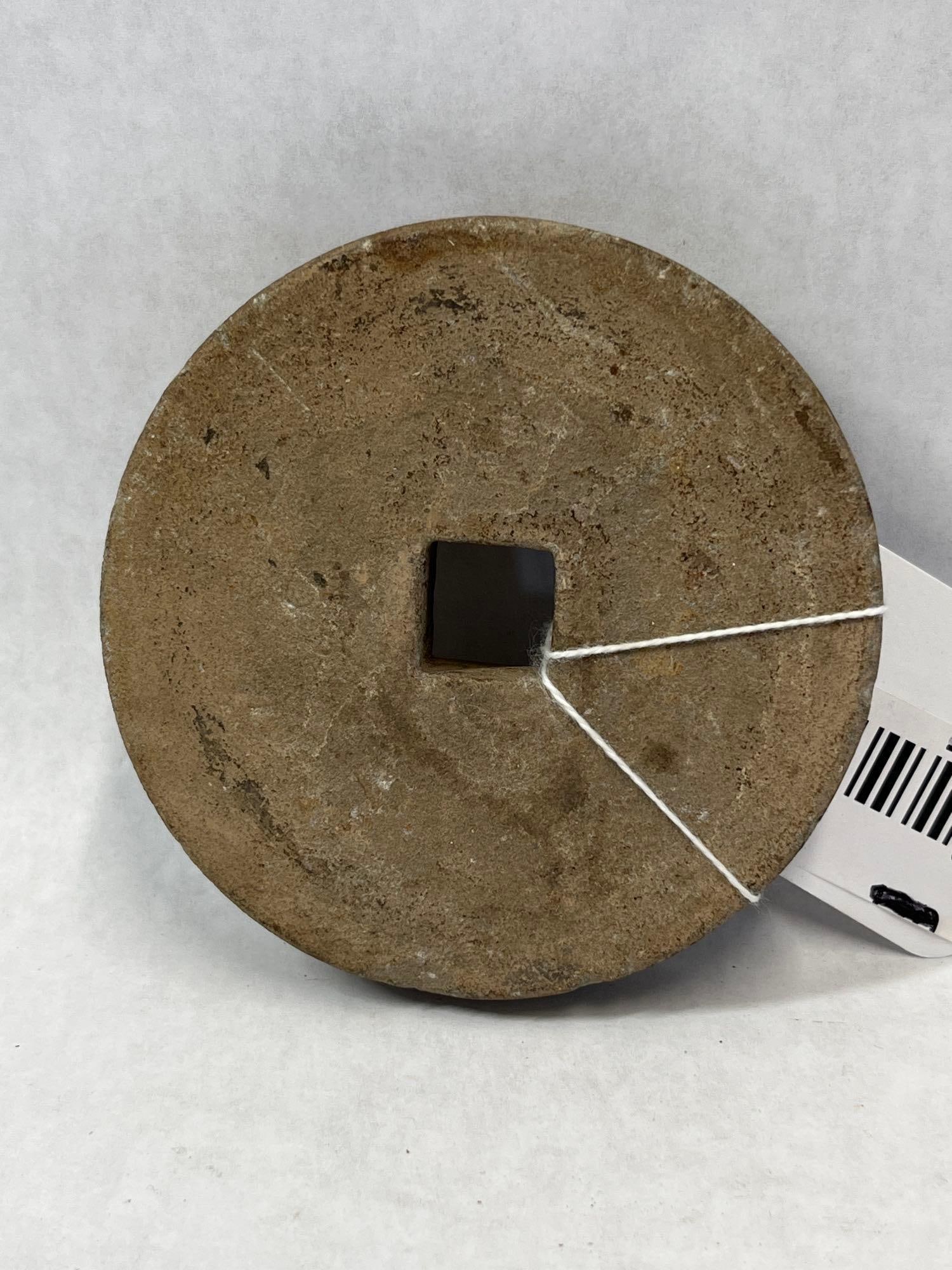 Chinese Carved Stone Circular Millstone Component: A utilitarian circular stone disc, possibly a small millstone or grinding wheel component, hand-carved from an earthy-toned, fine-grained sedimentary stone. The object features a central square-cut