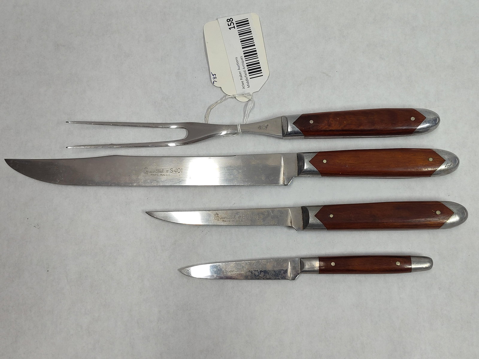 Set Queen Steel Stainless Steel Kitchen Cutlery: A set of kitchen cutlery manufactured by the Queen Cutlery Co. of Titusville, Pennsylvania. The collection features stainless steel blades and tines, branded under the proprietary Queen Steel name,
