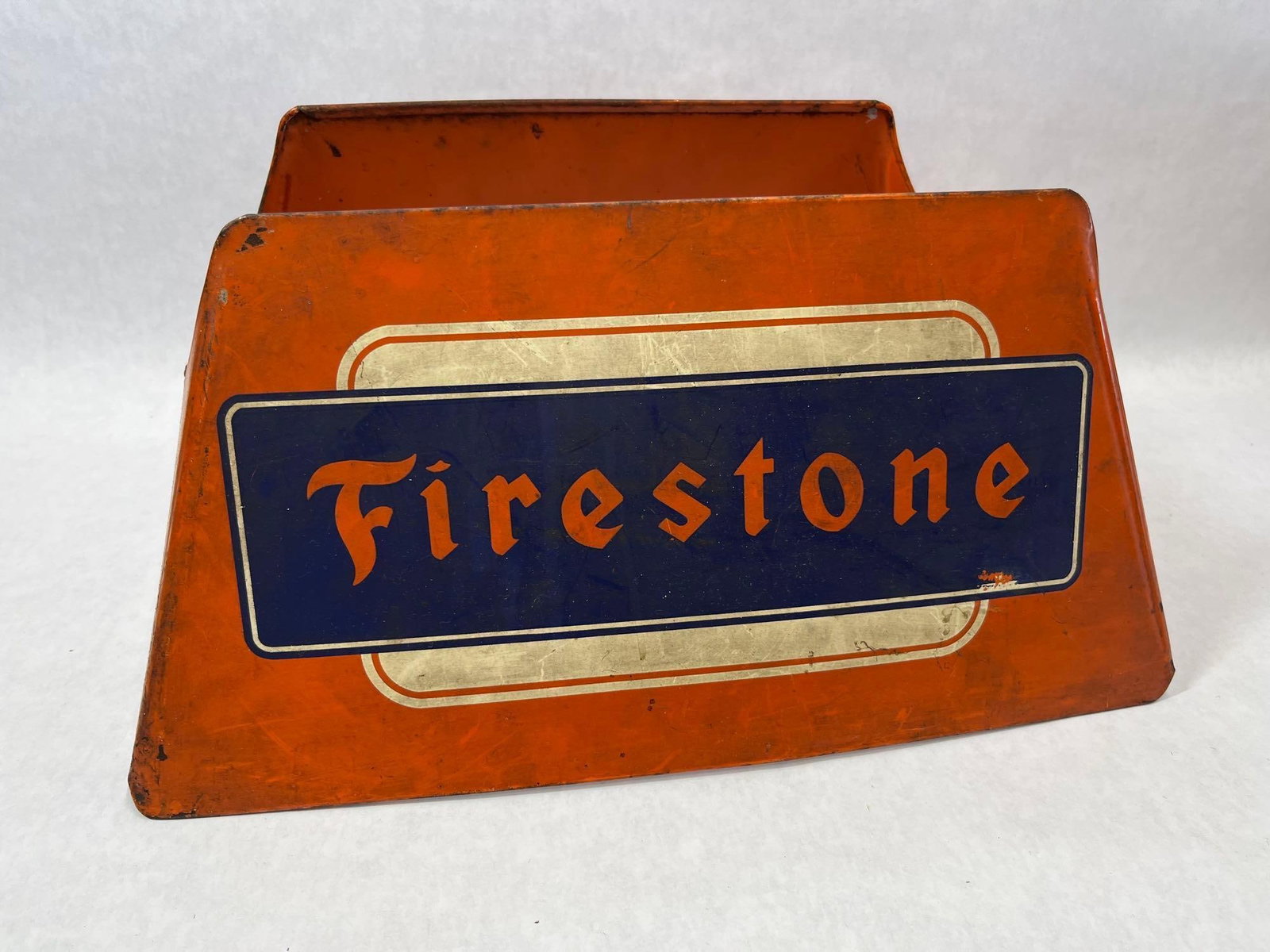 Firestone Metal Tire Display Stand by Cardinal Products: This is a mid-20th-century automotive advertising collectible designed for retail tire display. The stand is constructed from sheet metal with an orange painted finish. Both sides feature the