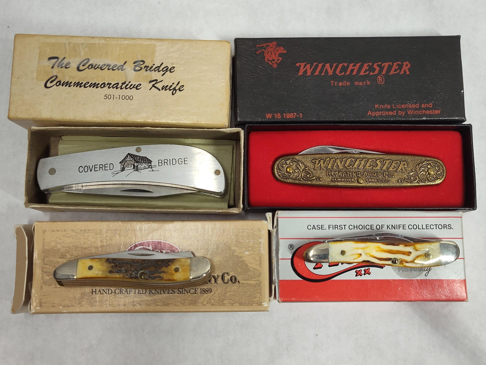 4 Winchester W15 & Case XX Folding Pocket Knives: This lot consists of four collectible folding pocket knives, each accompanied by its original box or presentation case. The collection includes a Winchester W15 1987-1 100th Anniversary Limited
