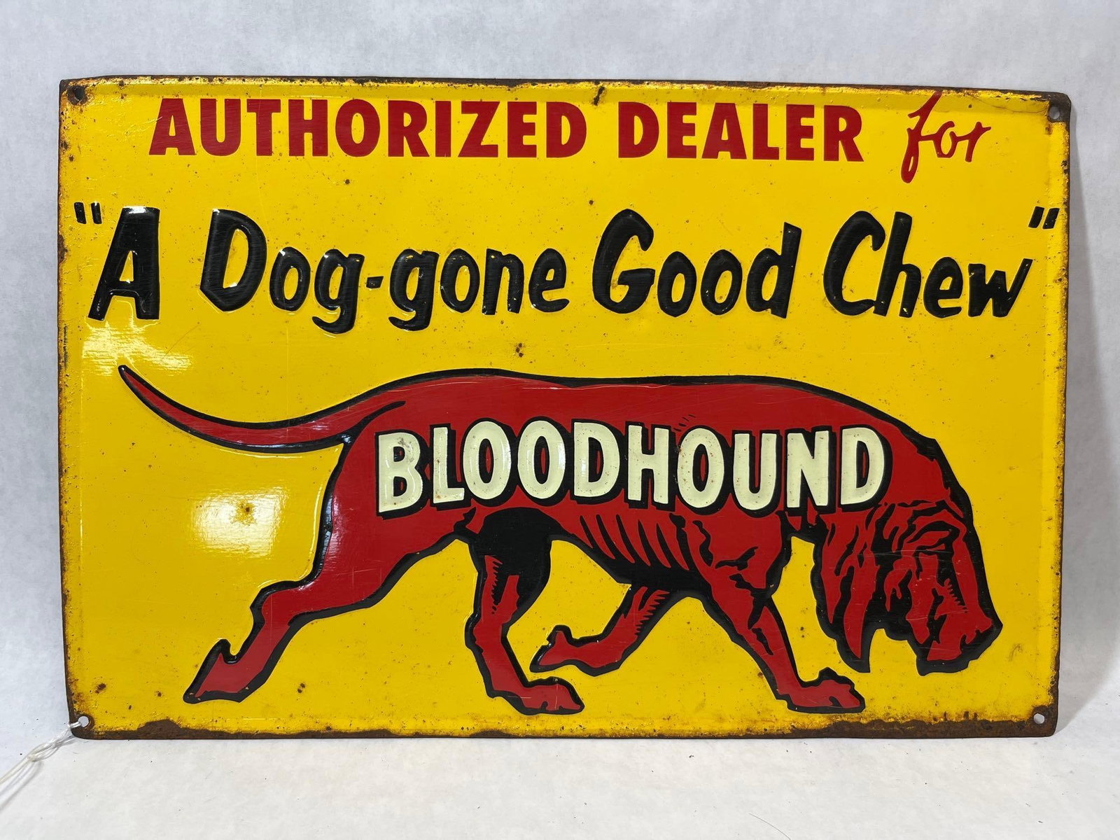 Bloodhound Chewing Tobacco Embossed Tin Sign: This is an embossed single-sided tin advertising sign for Bloodhound Chewing Tobacco. The rectangular sign features a yellow background with text and graphics. At the top, the sign reads AUTHORIZED