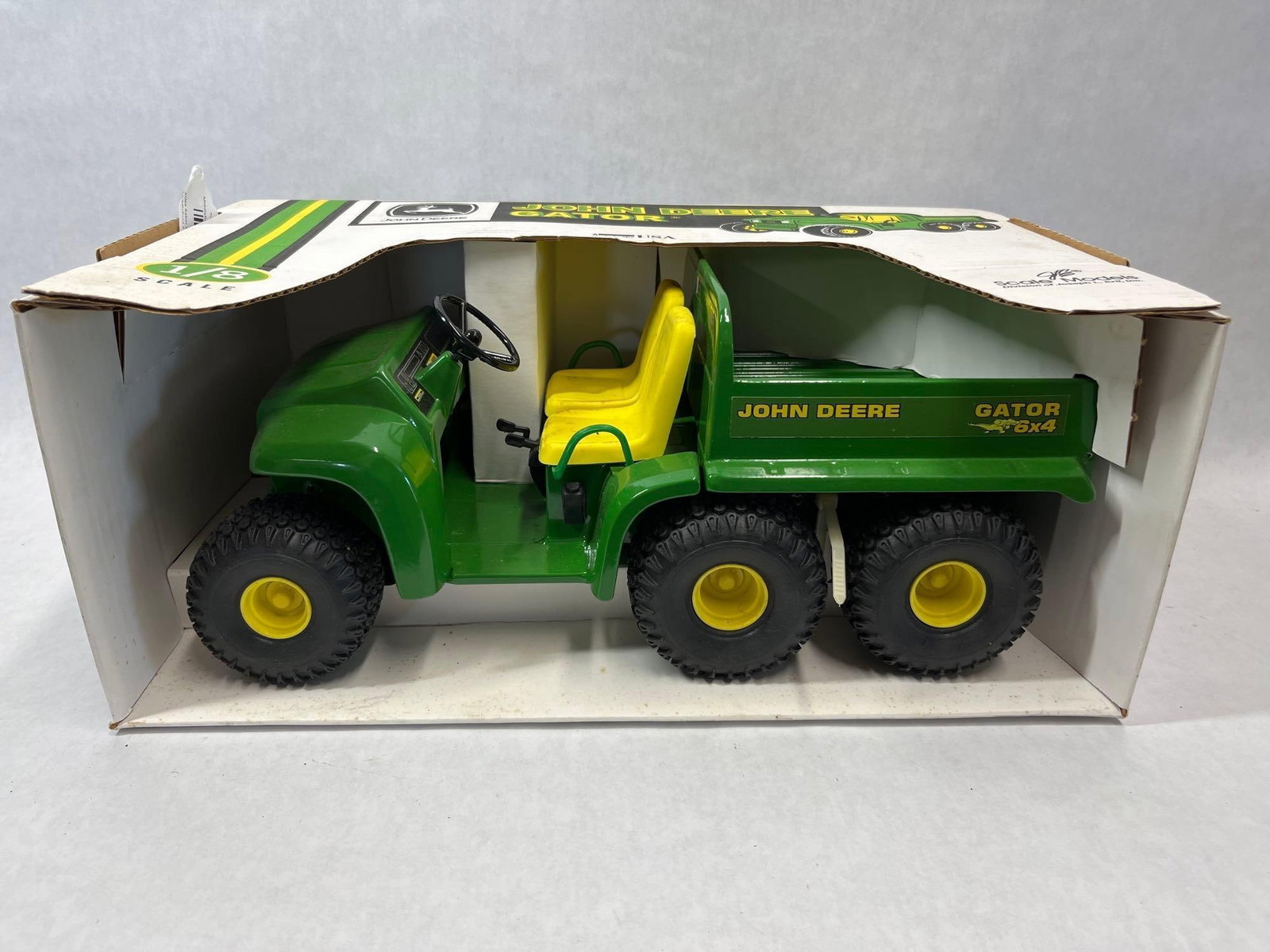 Scale Models John Deere Gator 6x4 1/8 Model w/ Box: This 1/8 scale model represents a John Deere Gator 6x4 utility vehicle, manufactured by Scale Models, a division of Joseph L. Ertl, Inc. based in Dyersville, Iowa. The model is constructed with a