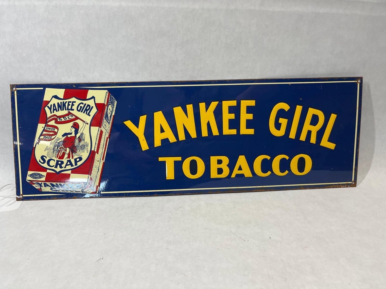 Yankee Girl Tobacco Embossed Tin Advertising Sign: A rectangular antique lithographed tin advertising sign for Yankee Girl Tobacco, a product of the Scotten, Dillon Company of Detroit, Michigan. The sign features a deep blue field with large, yellow