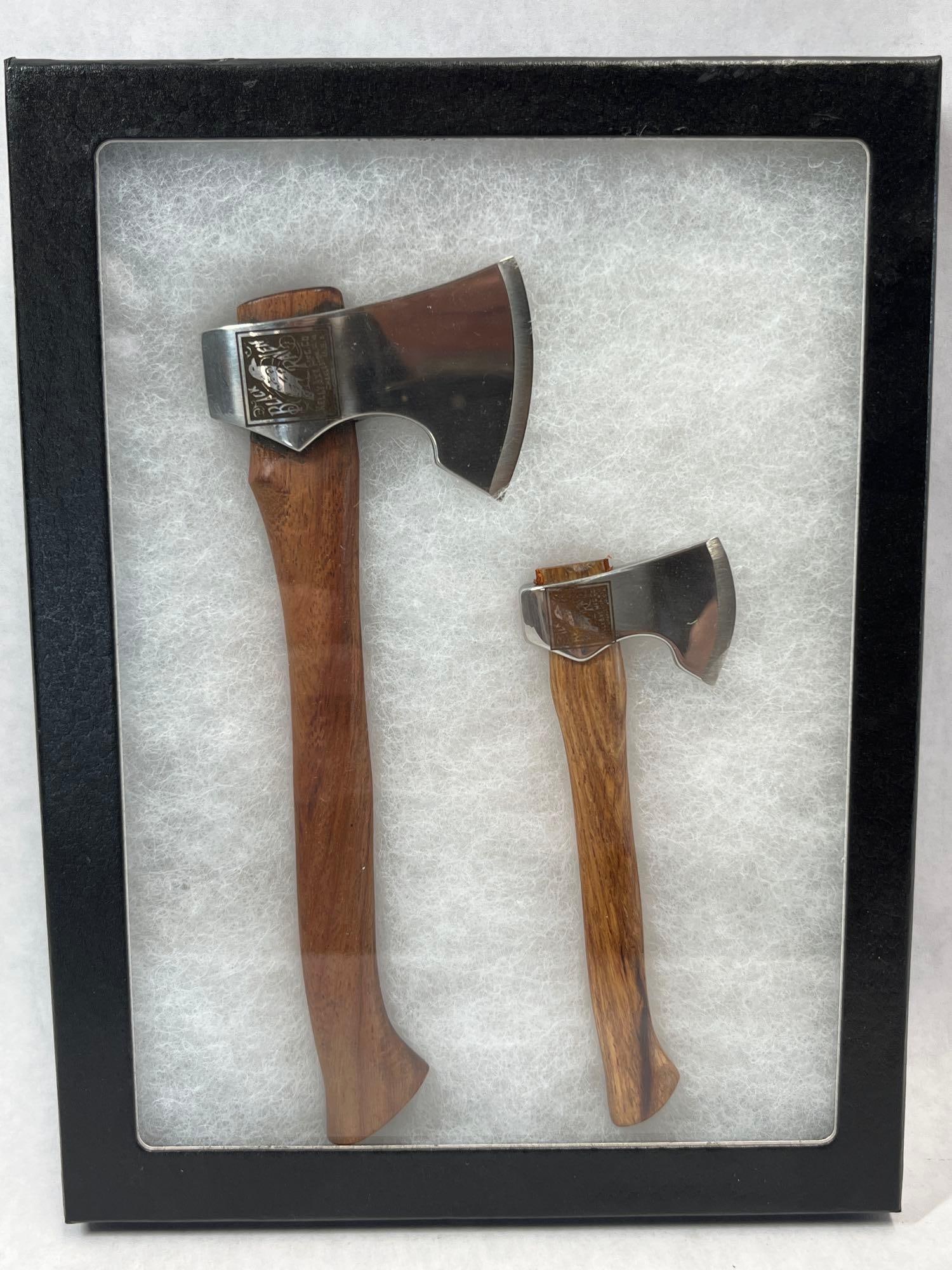 Pair Kelly Black Raven Commemorative Axes in Box: A set of two miniature axes featuring polished metal heads and stained wooden handles. These items are contemporary commemorative pieces modeled after the iconic Black Raven pattern produced by the