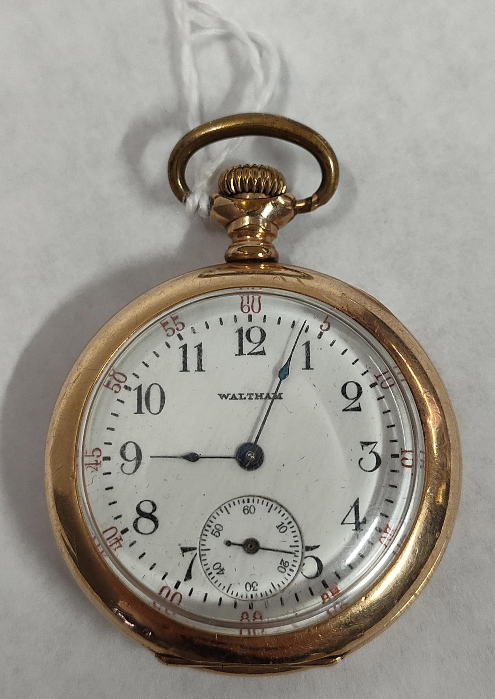 Waltham Gold-Filled Open-Face Pocket Watch: A open-face pocket watch by Waltham. The white enamel dial features black Arabic numeral hour markers, an outer minute track with red Arabic numerals at five-minute intervals, and a subsidiary seconds