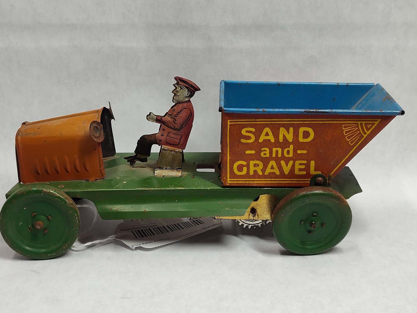 Ferdinand Strauss Wind-Up Sand & Gravel Dump Truck: This is a Ferdinand Strauss Corporation Sand and Gravel clockwork dump truck, manufactured in the United States during the early 20th century. The toy is constructed of lithographed tin (sheet metal)