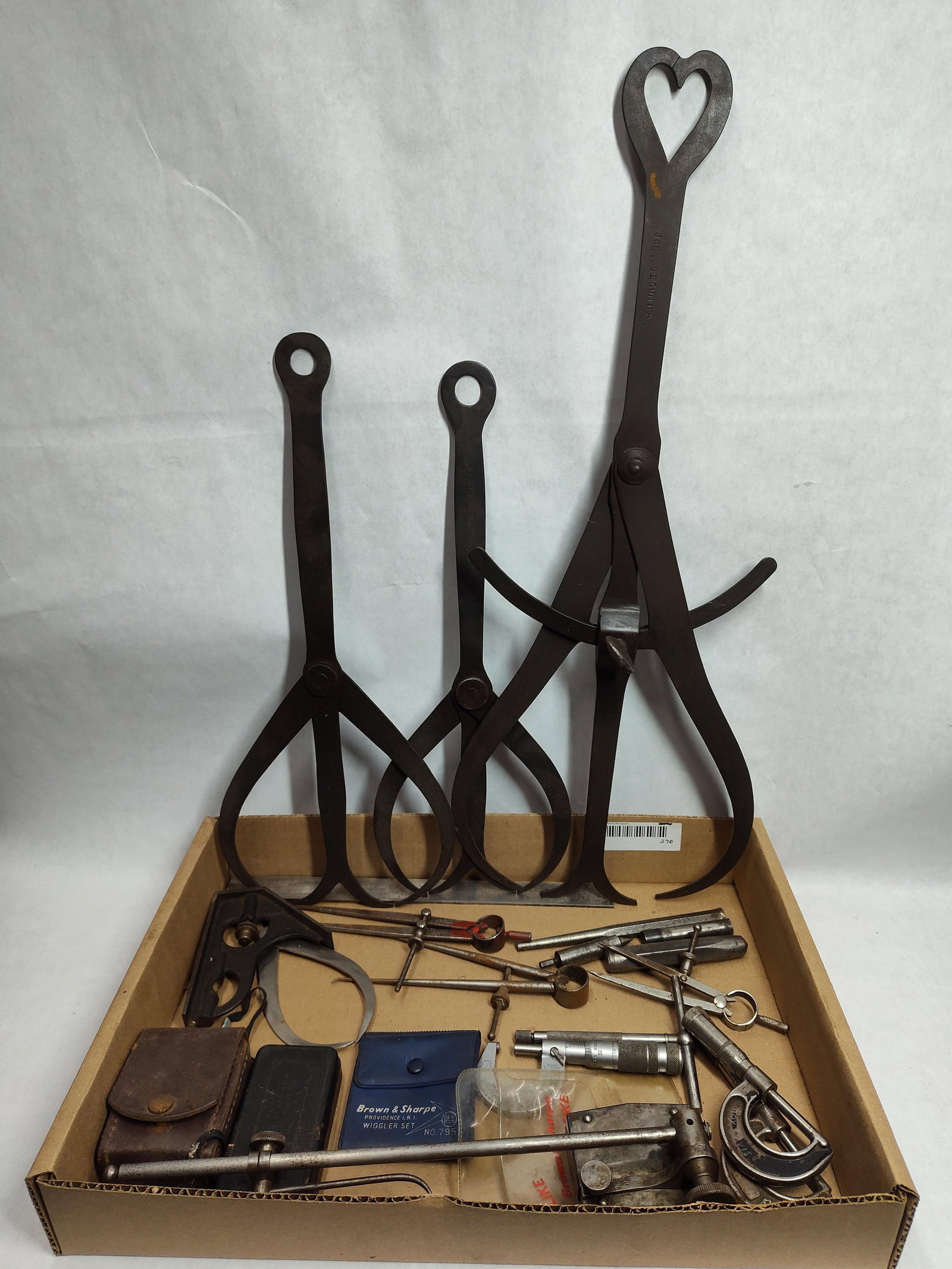 Brown & Sharpe & Gem Machinist & Blacksmith Tools: This assortment consists of a variety of precision measuring and layout tools related to the machinist and blacksmith trades. The group features three oversized forged steel double calipers, often uti