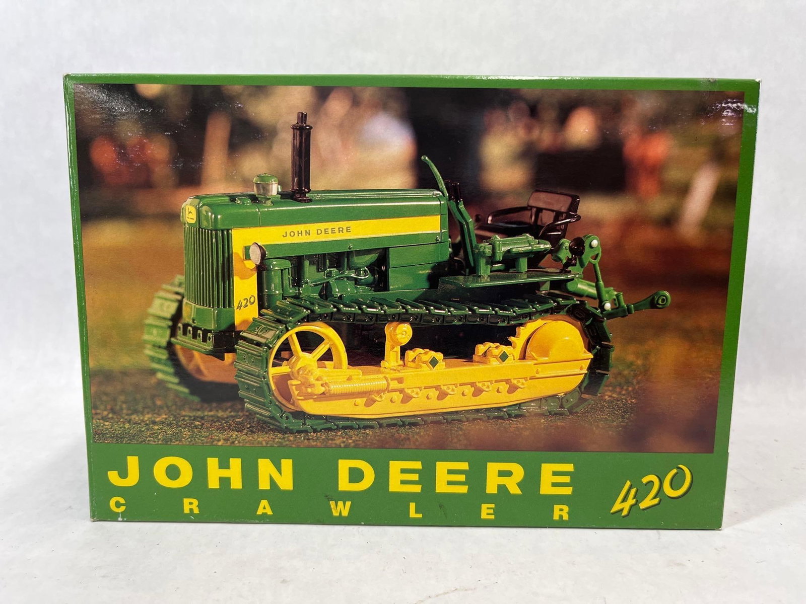 Ertl John Deere 420 Crawler Pow City Farm Toy Show: A die-cast metal model of a John Deere 420 Crawler tractor in 1/16 scale, produced by Ertl. This specific model was released as a commemorative edition for the Eighteenth Annual Pow City Farm Toy
