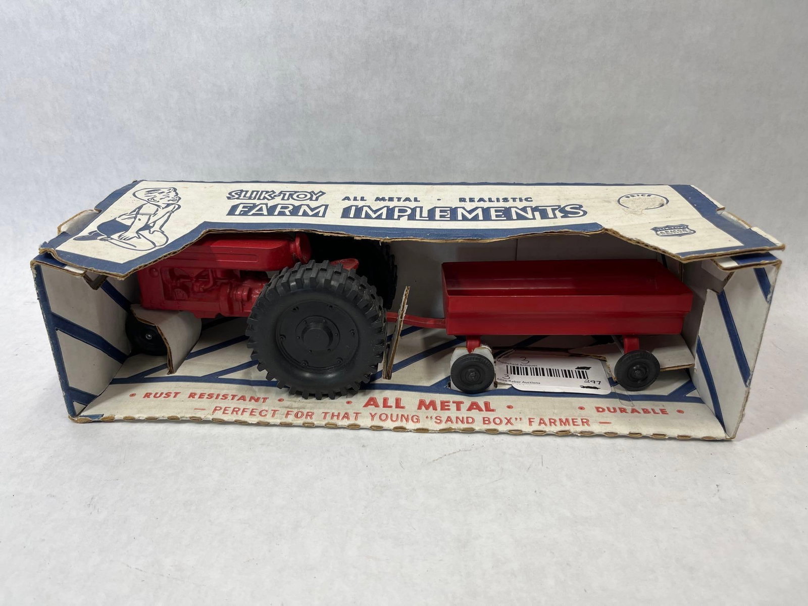 Slik-Toy Farmall Tractor & Wagon Set w/ Box: A Slik-Toy Farm Implements set manufactured by the Lansing Company of Muscatine, Iowa. This set consists of a red tractor, modeled after an International Harvester Farmall, and a matching red two-whee