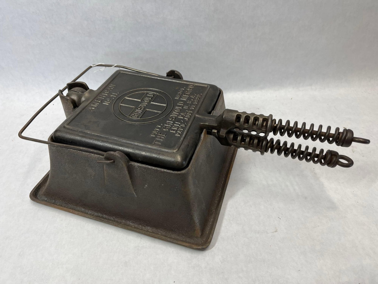 Griswold No. 11 Square Waffle Iron w/ High Base: This is a cast iron waffle iron manufactured by The Griswold Manufacturing Company in Erie, Pennsylvania. The set includes two square articulated paddles and a matching high-profile base designed for