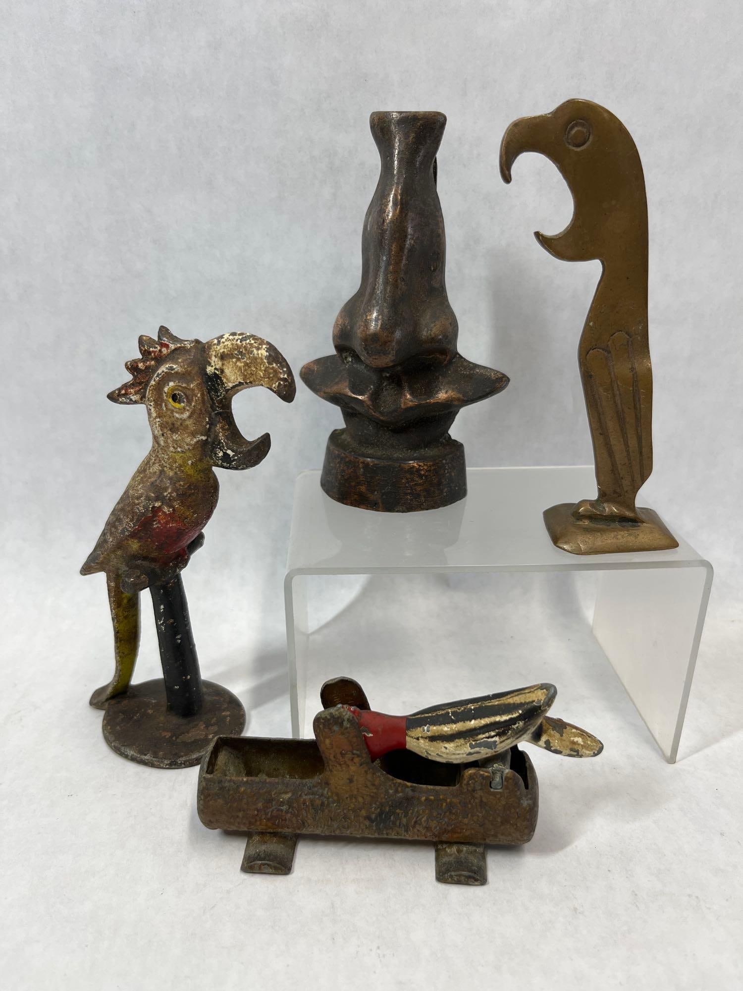 Figural Barware & Tabletop Novelties: This collection consists of several figural metal items, primarily barware and tabletop mechanical novelties. Included is a painted parrot bottle opener, attributed to John Wright, designed with the