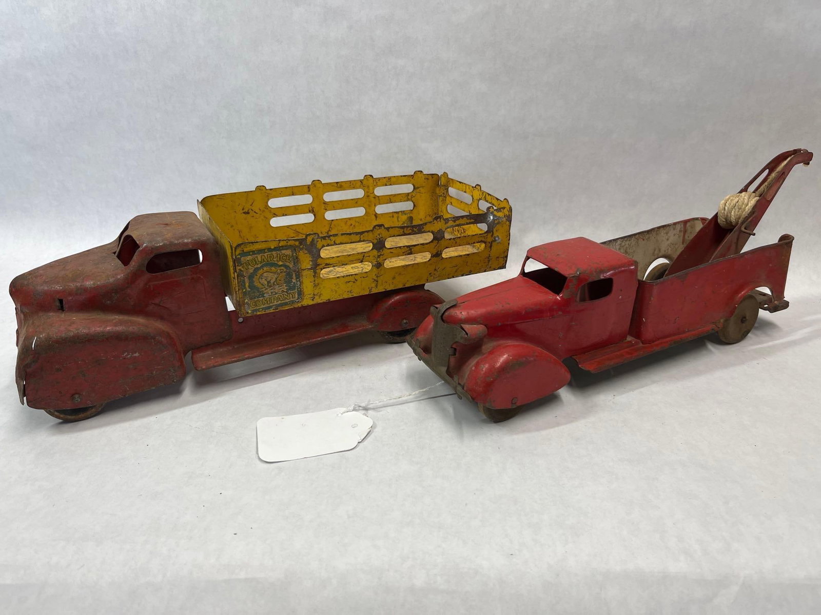 Pair Star Toys Pressed Steel Stake & Wrecker: This lot features two pressed steel toy trucks manufactured by Star Toys of America, dating to approximately the 1940s or 1950s. The first item is a stake-side delivery truck with a red cab and a
