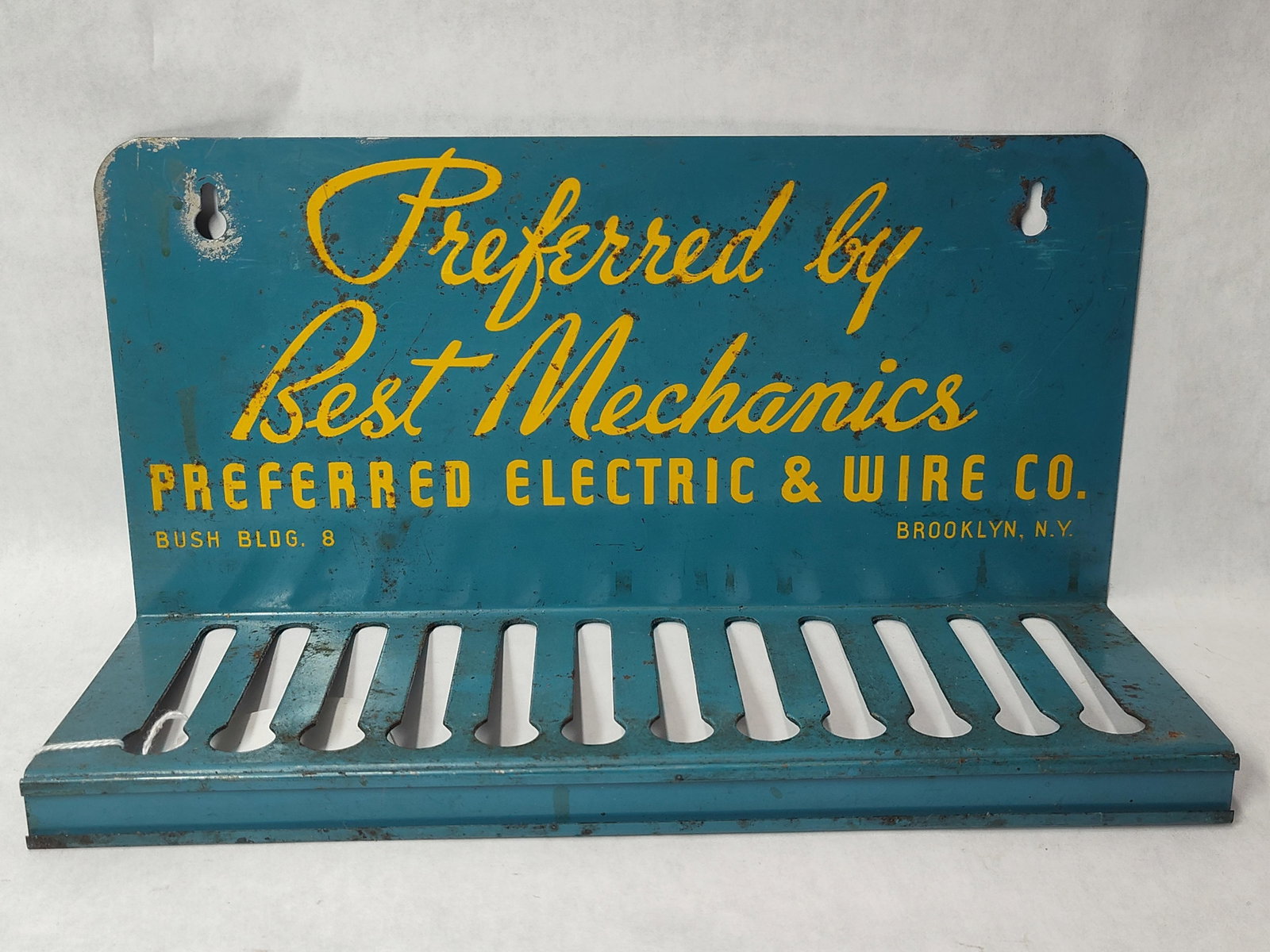 Preferred Electric & Wire Co. Painted Metal Automotive Display Rack: This painted metal advertising display rack was produced for the Preferred Electric & Wire Co. The unit consists of a single piece of sheet metal formed into a vertical backplate and a horizontal