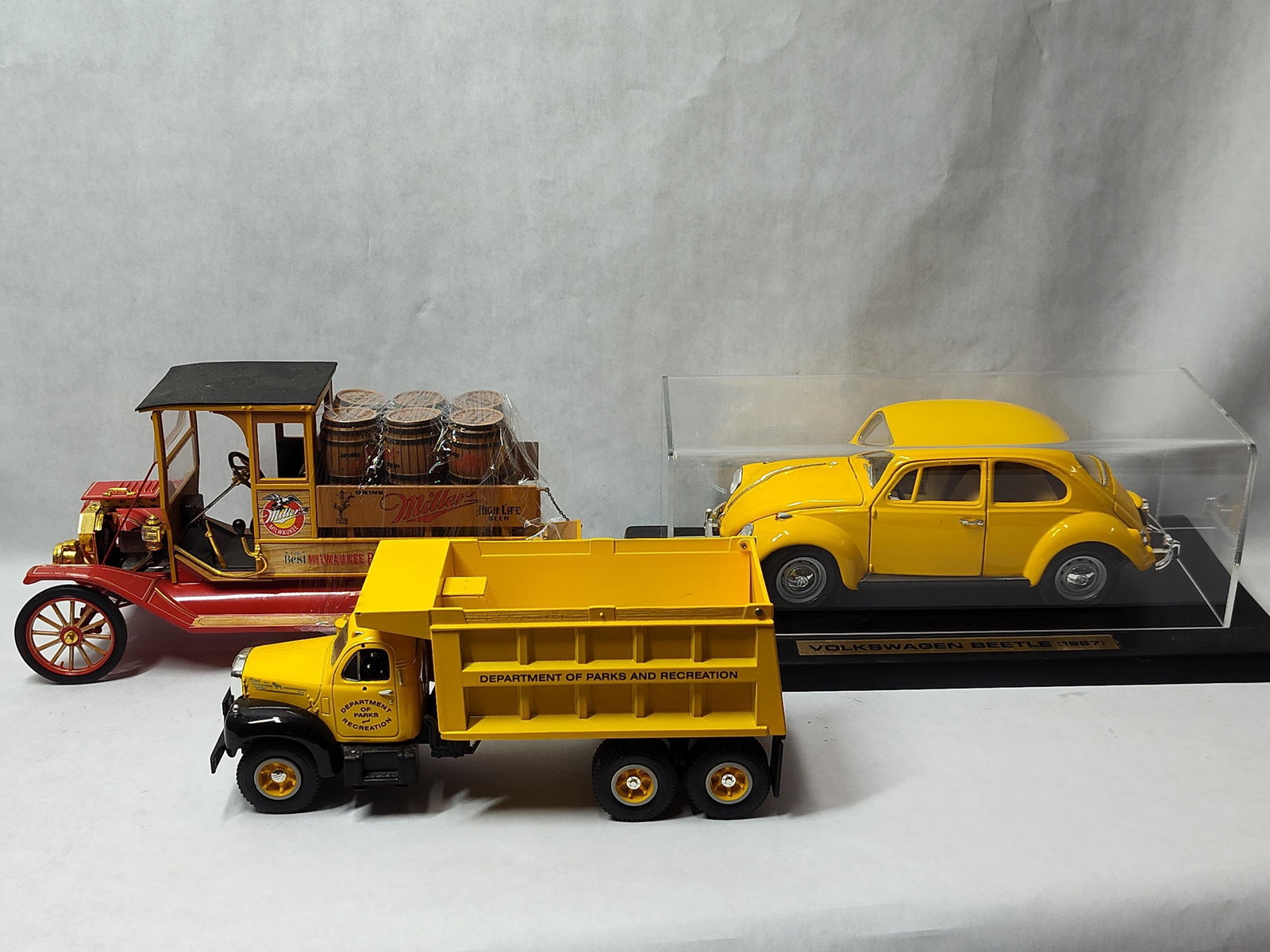 Set 3 Die-cast Ford, Volkswagen & Mack Vehicles: A trio of detailed die-cast collectible vehicles of varying scales. The first is a 1913 Ford Model T Miller Beer delivery truck, attributed to Franklin Mint Precision Models. Constructed of die-cast m
