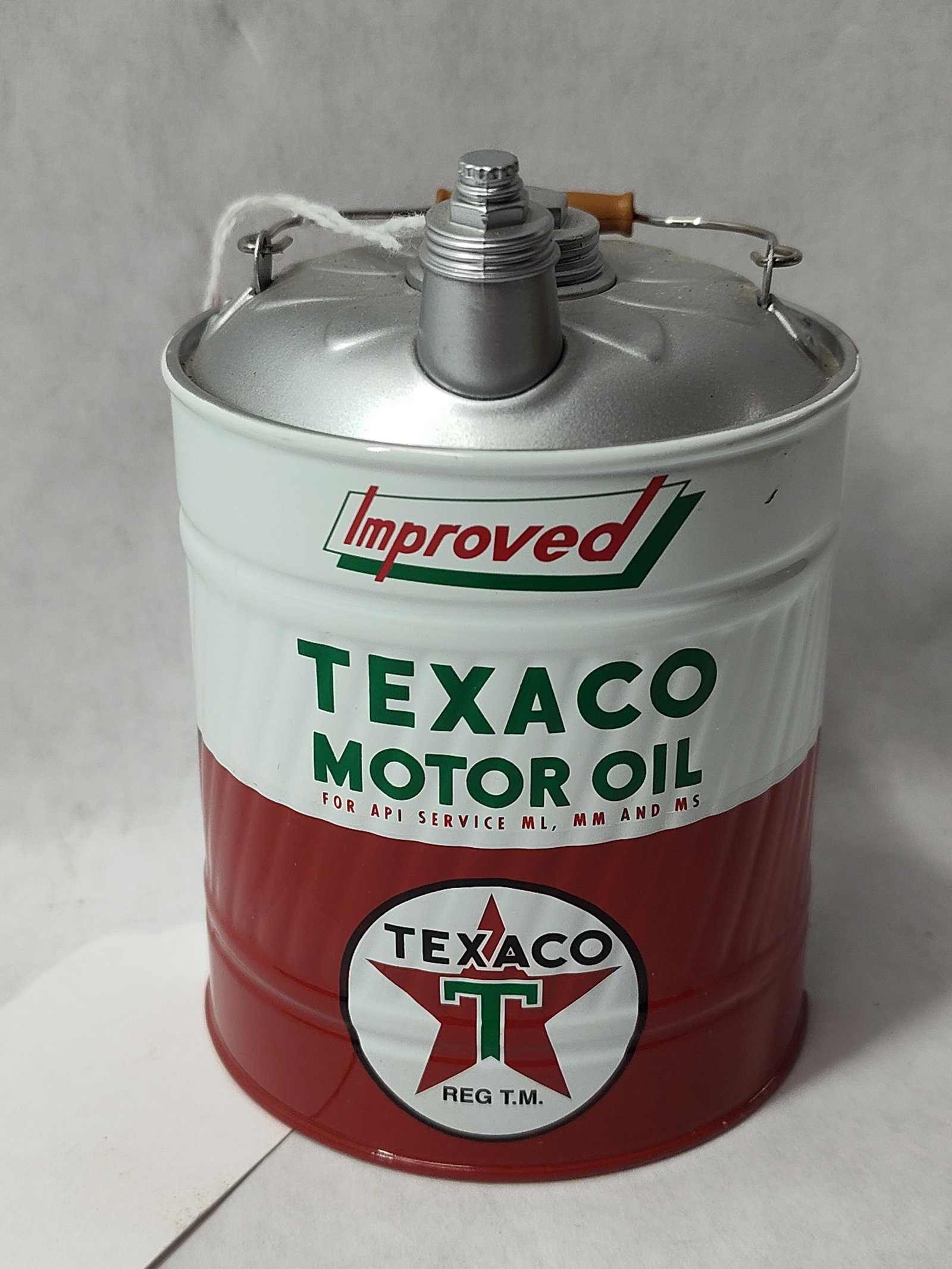 Texaco Improved Motor Oil Promotional Drum: This item is a lithographed tin scale miniature replicating a five-gallon Texaco motor oil drum. The exterior features a tricolor scheme of red, white, and green. The upper portion displays the word