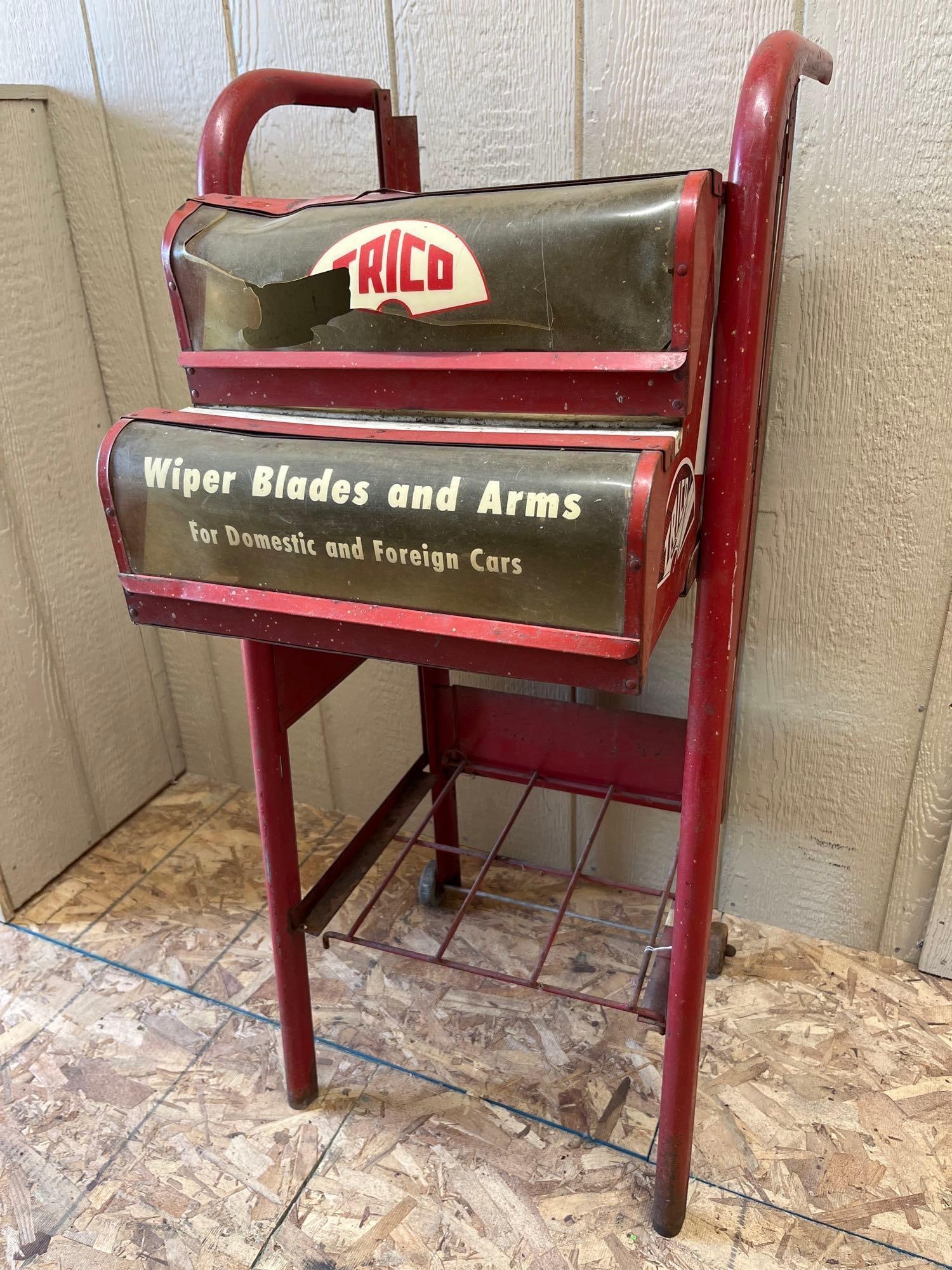Trico Windshield Wiper Blade & Arm Display Cart: A mid-century Trico branded floor-standing rolling service station display cabinet. This point-of-purchase unit is constructed from a red-painted steel frame and sheet metal cabinet. The upper
