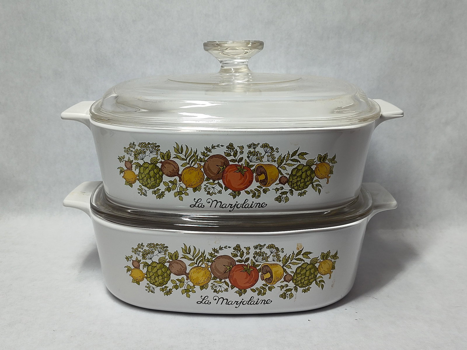 Pair Corning Ware Spice of Life Casseroles w/ Lids: This pair of casserole dishes is manufactured by Corning Ware and features the La Marjolaine pattern from the Spice of Life series. Each dish is constructed from white Pyroceram glass-ceramic and is